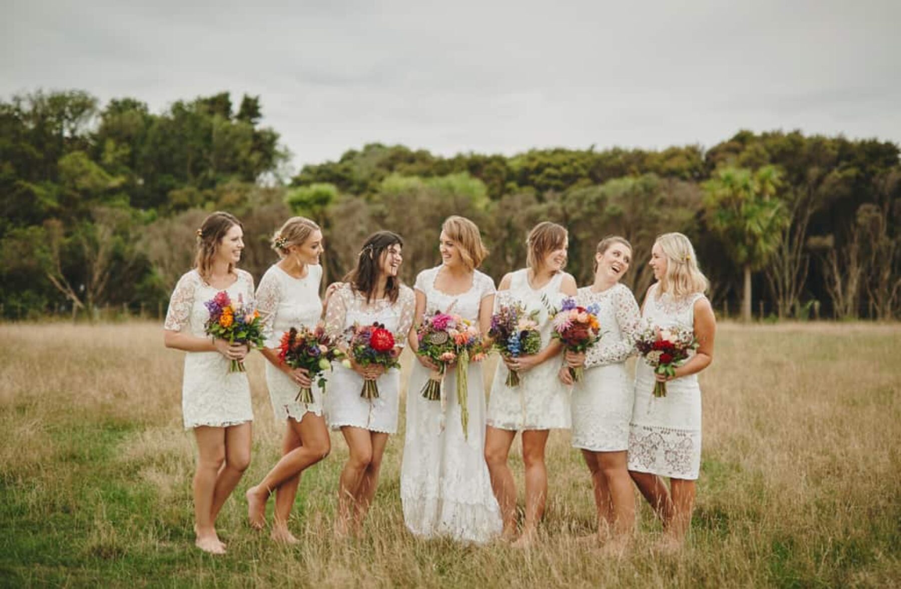 Bridesmaids in white with vibrant bouquets