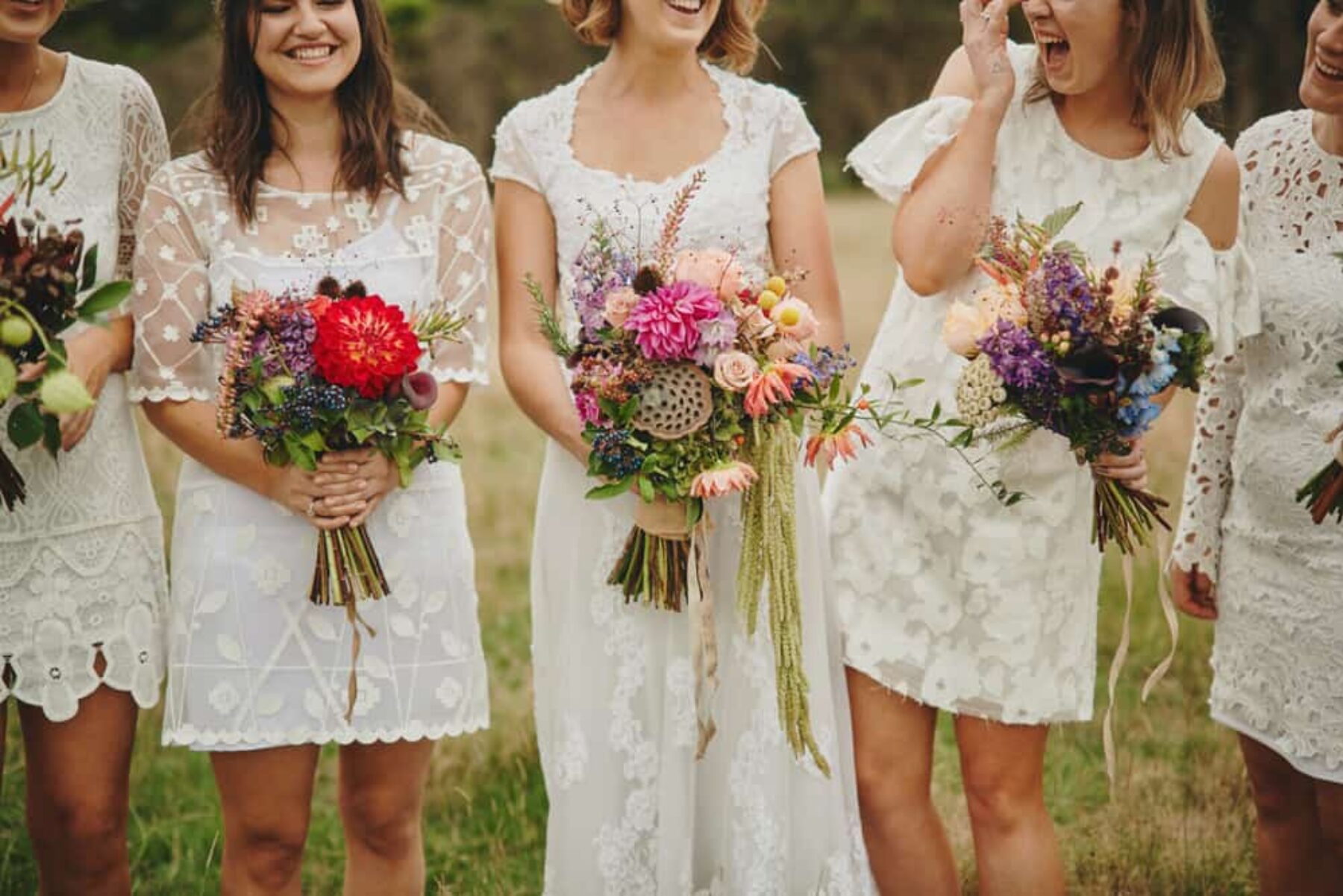 Bridesmaids in white with vibrant bouquets