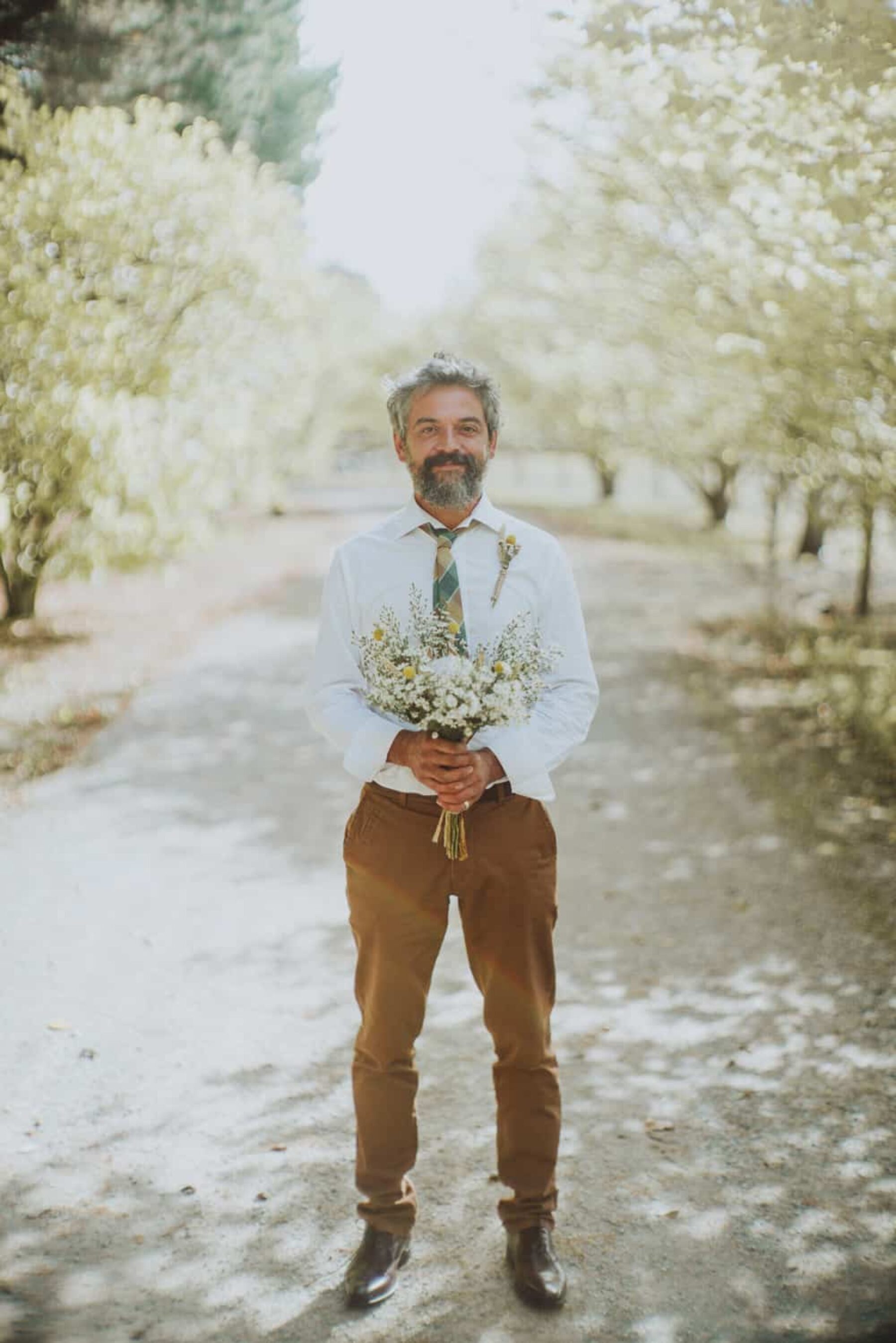 laid back groom with bouquet