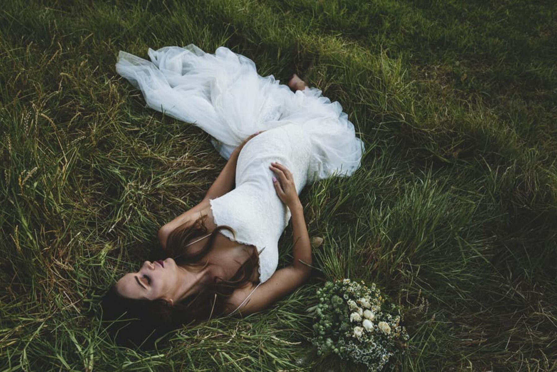 boho bride laying on grass