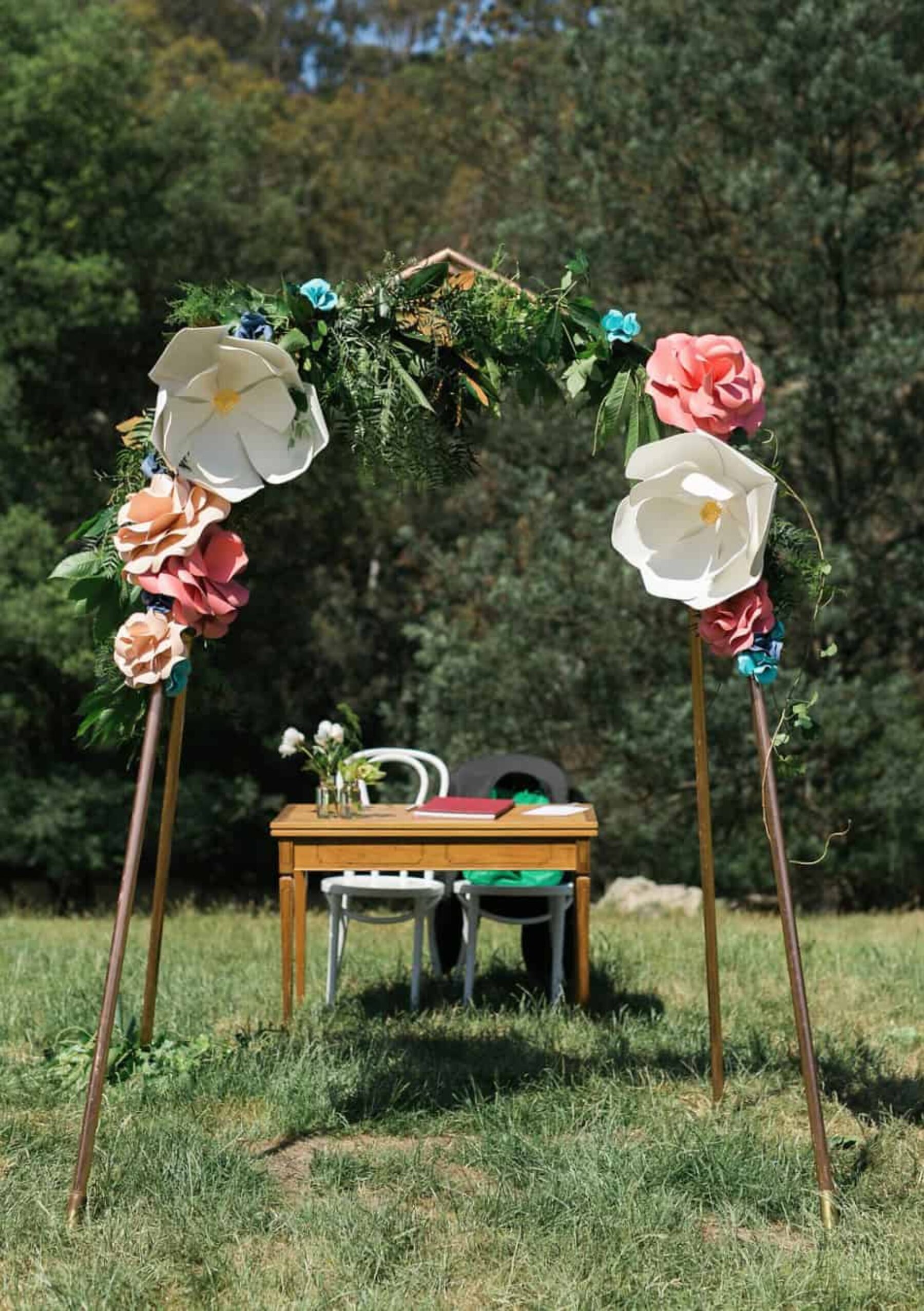 copper arch with giant paper flowers