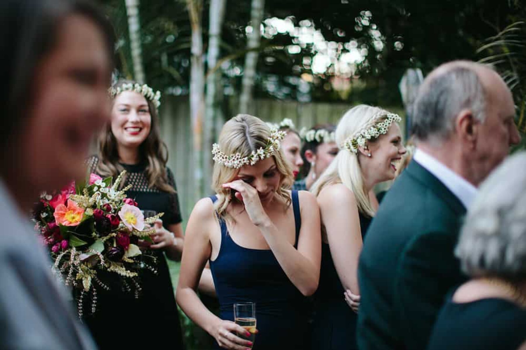 bridesmaids in black dresses and white flower crowns