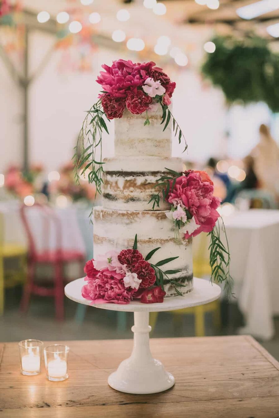 3 tier semi-naked wedding cake decorated with fresh pink flowers