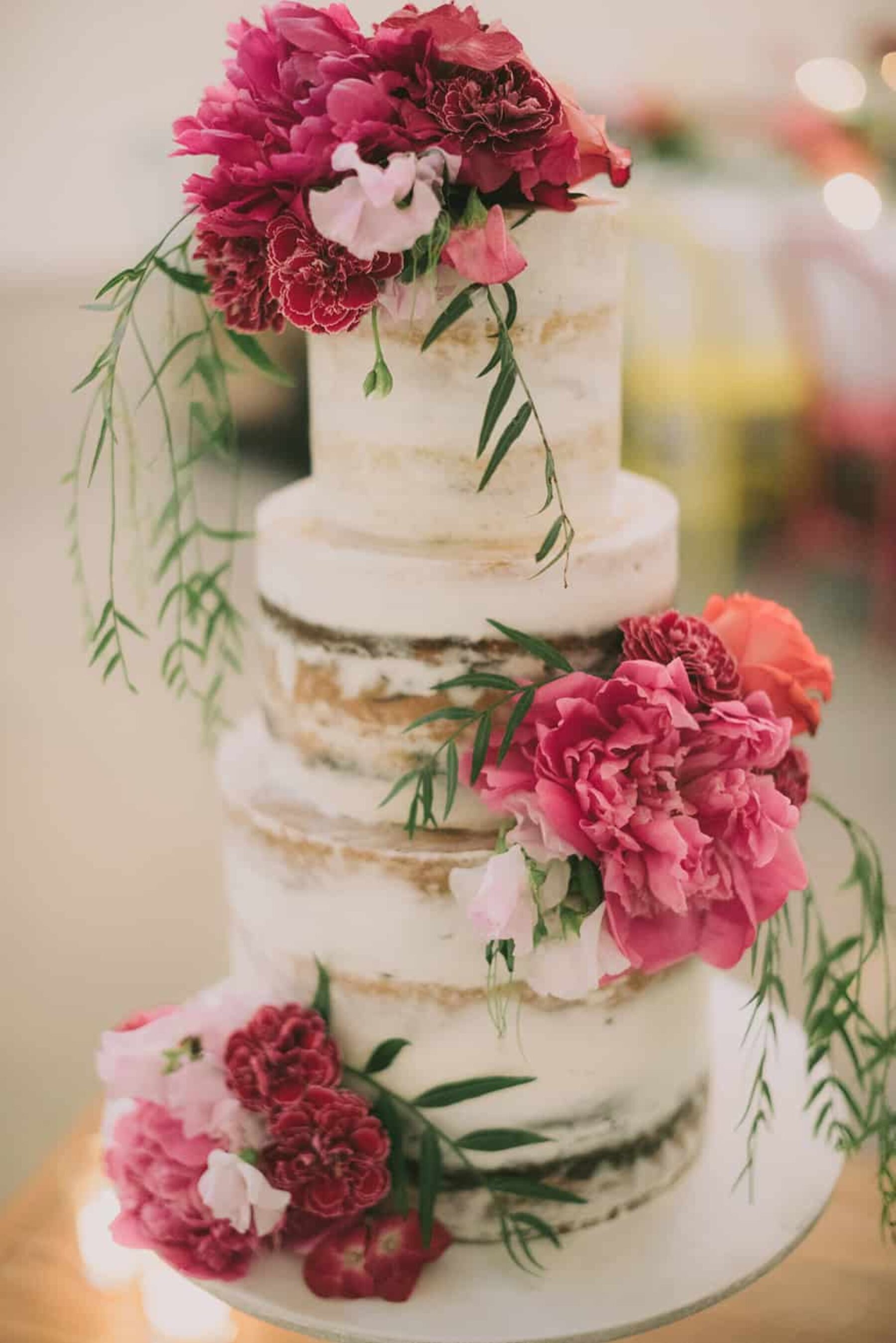 3 tier semi-naked wedding cake decorated with fresh pink flowers
