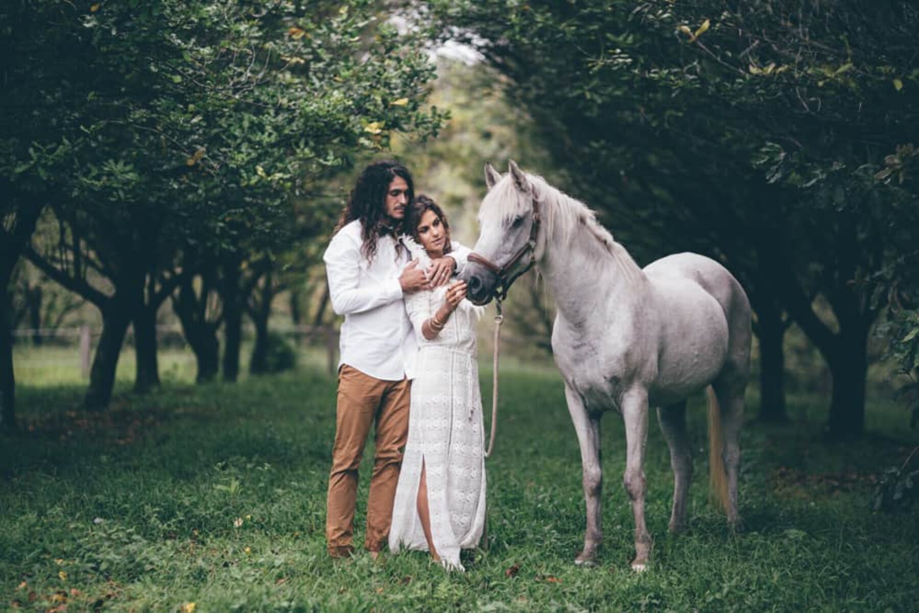 boho bride and groom with white horse