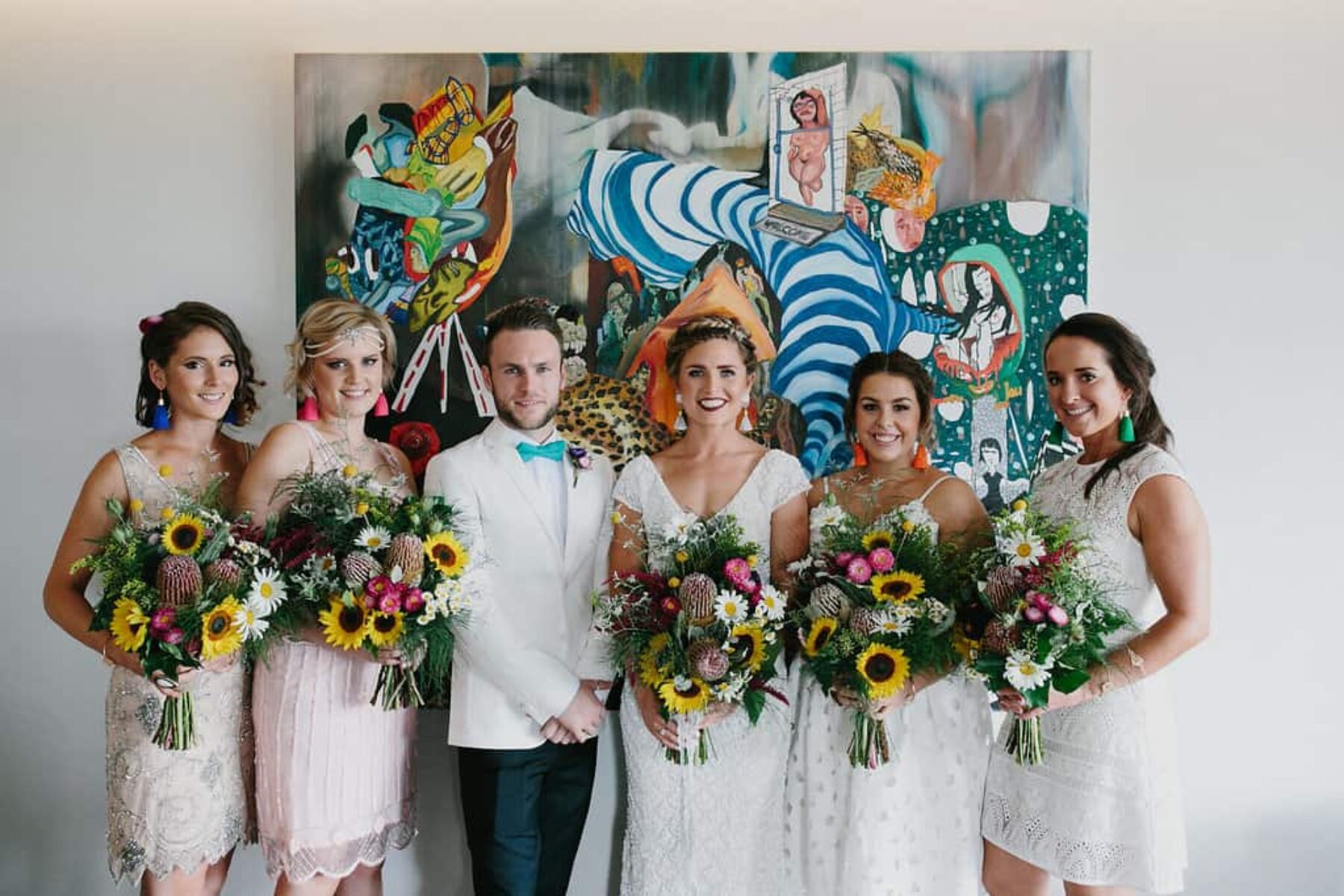 bride, bridesmaids and bridesman with colouful bouquets