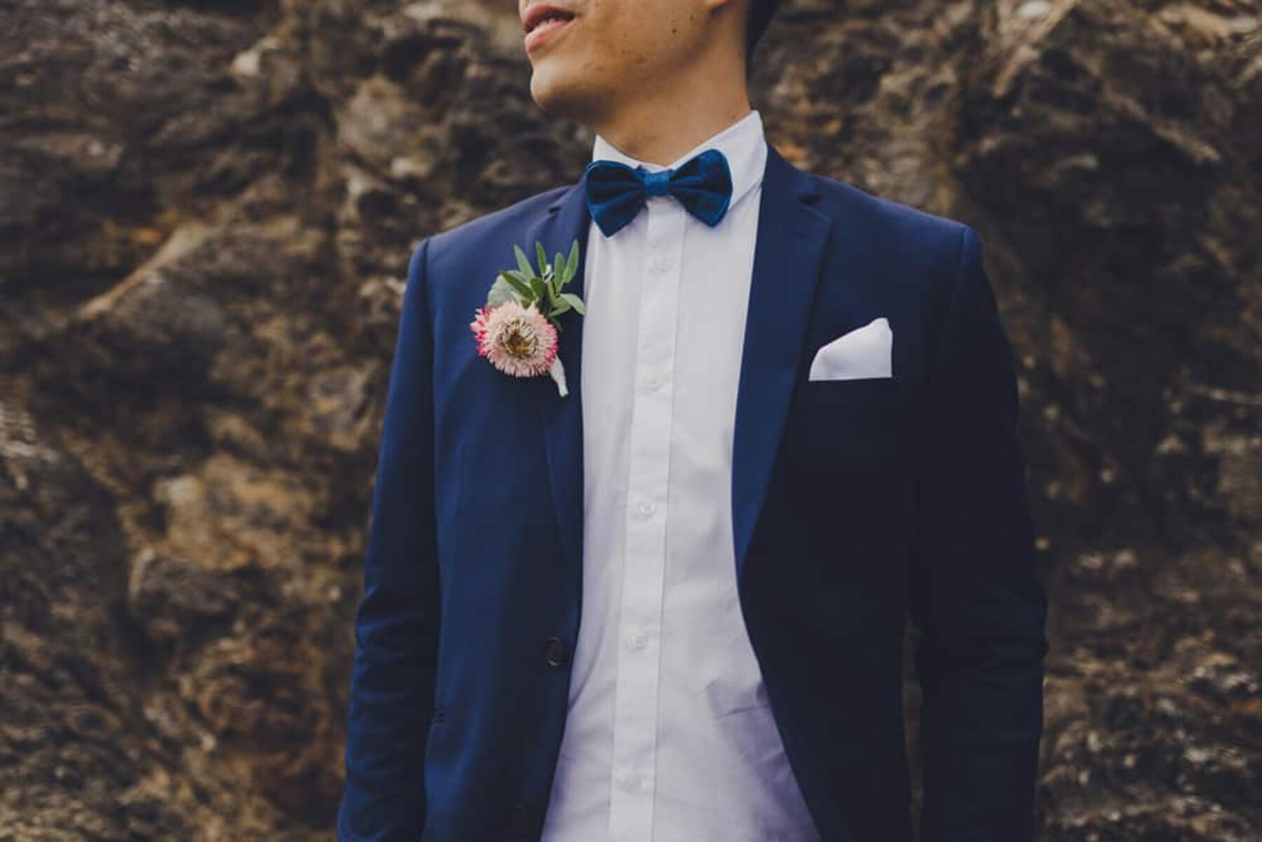 groom wearing royal blue suit and bow tie
