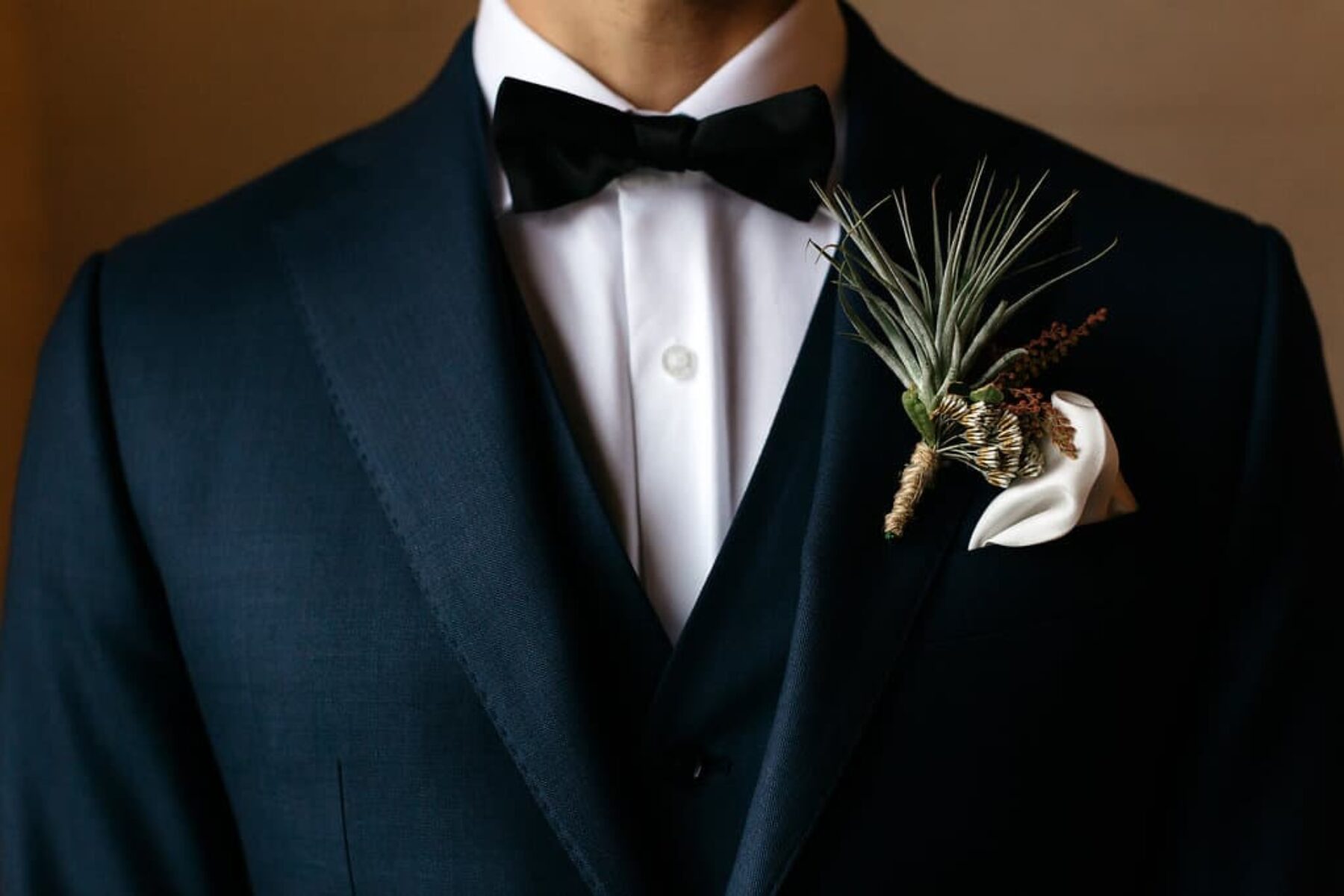 Stylish groom in Oscar Hunt with native boutonniere