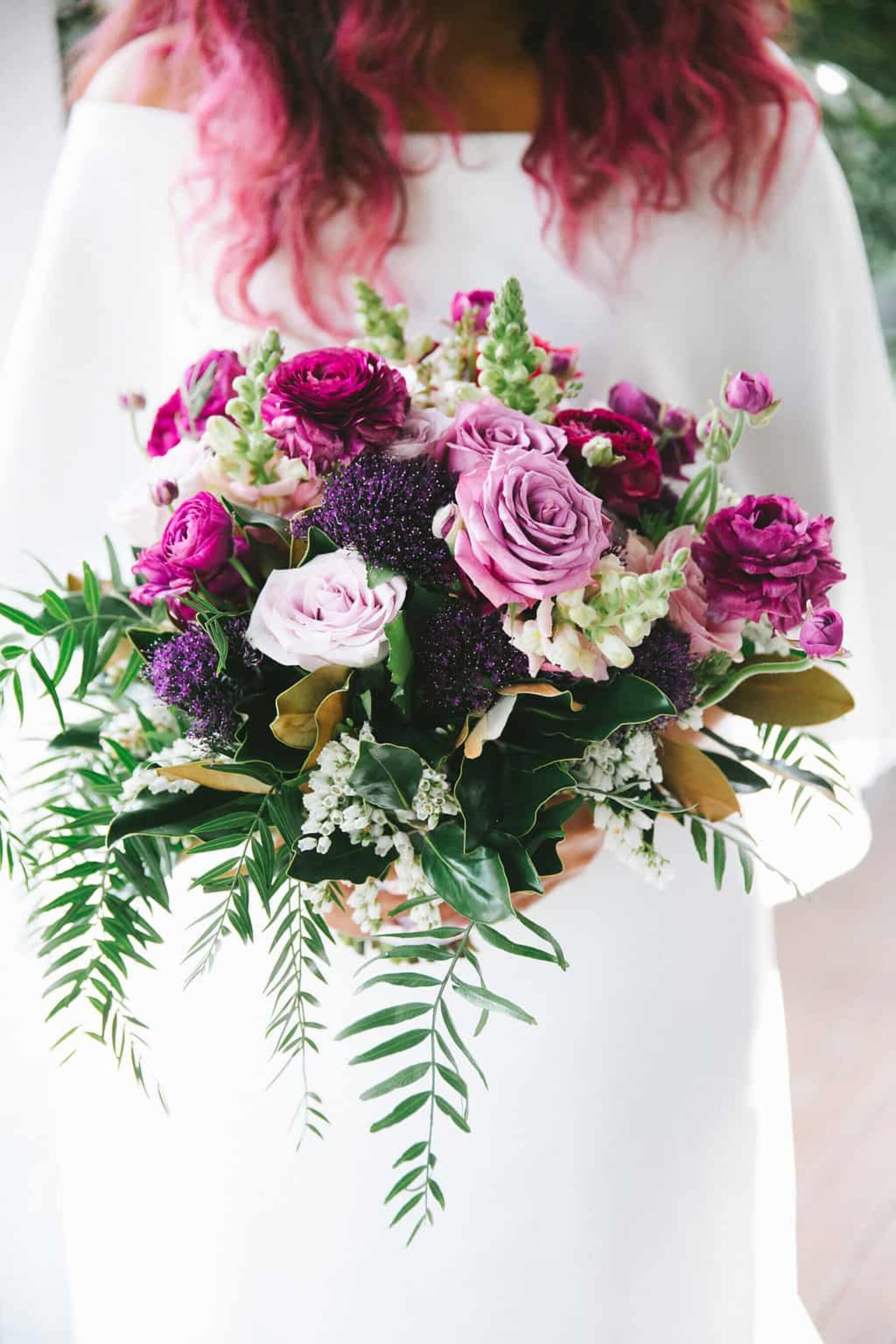 pink-haired bride with purple rose bouquet
