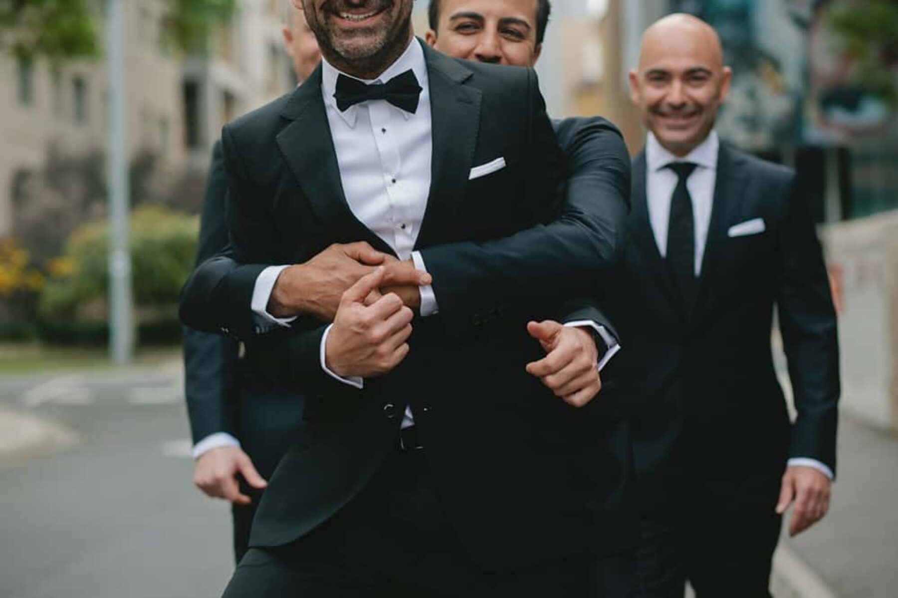 Groomsmen in black suits from Calibre