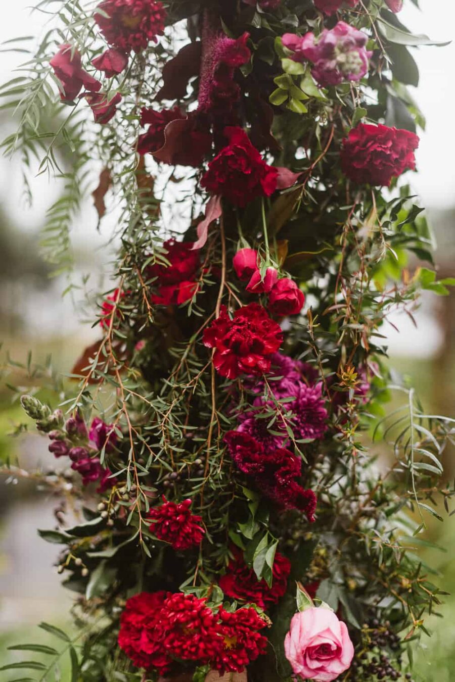berry-toned floral wedding arch