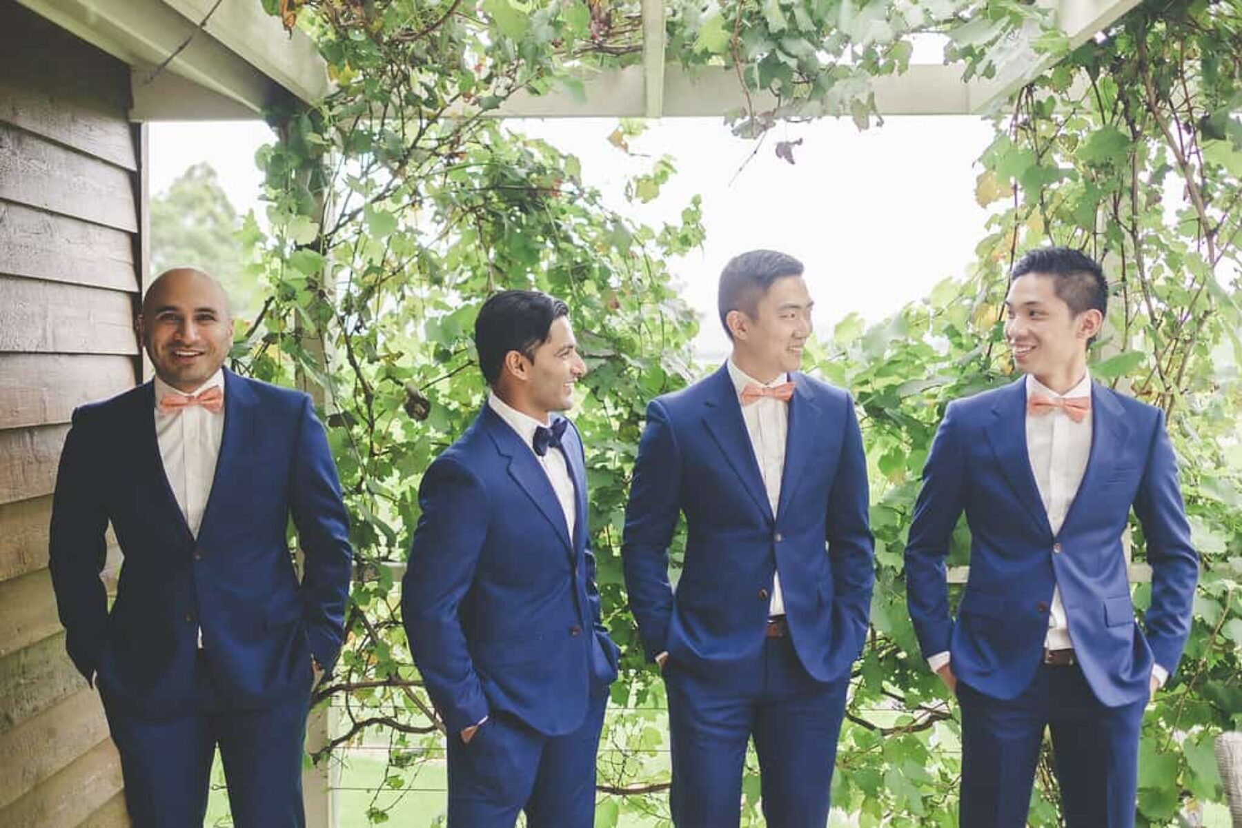 groomsmen in blue suits and bow ties