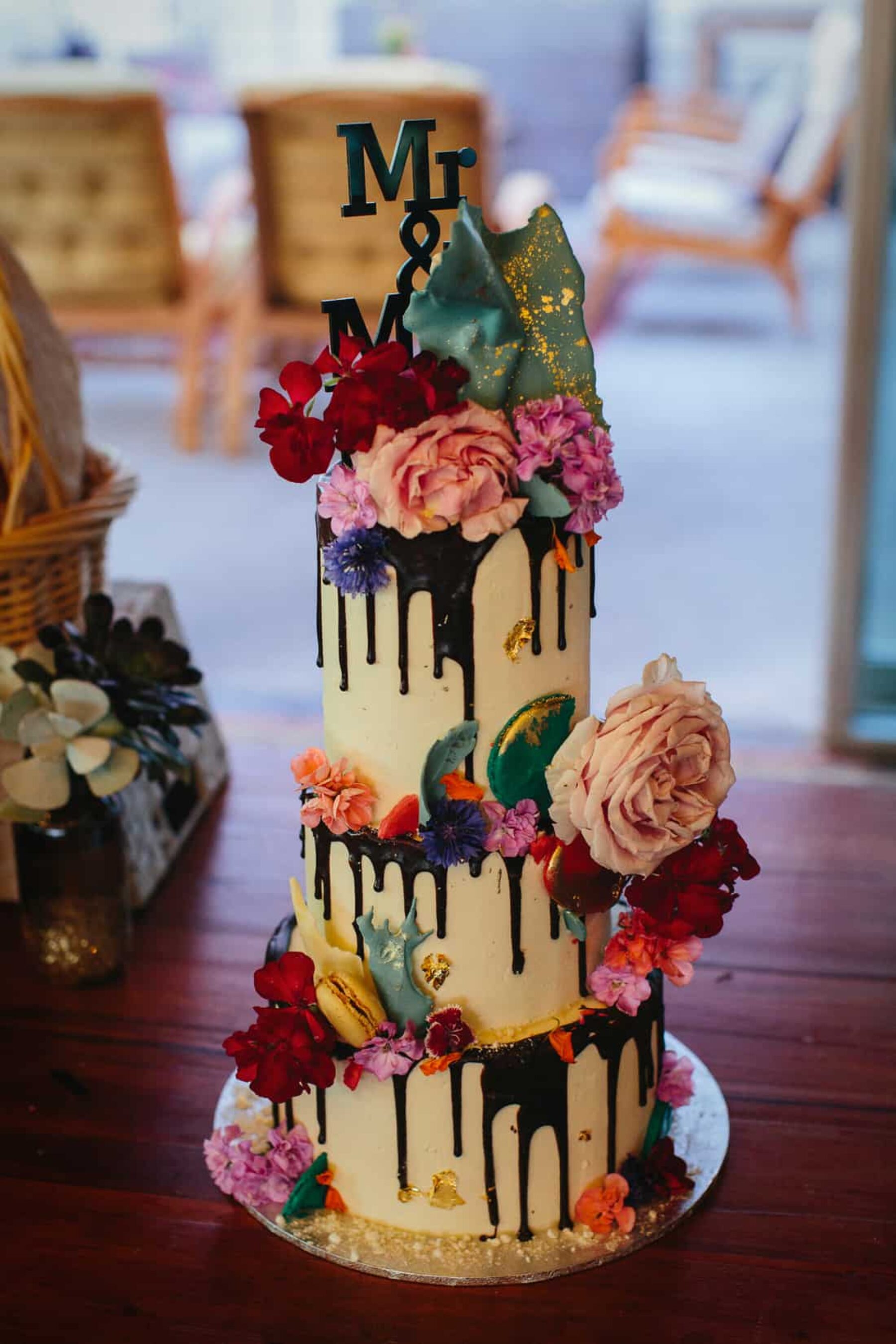creative three-tier wedding cake with chocolate drip