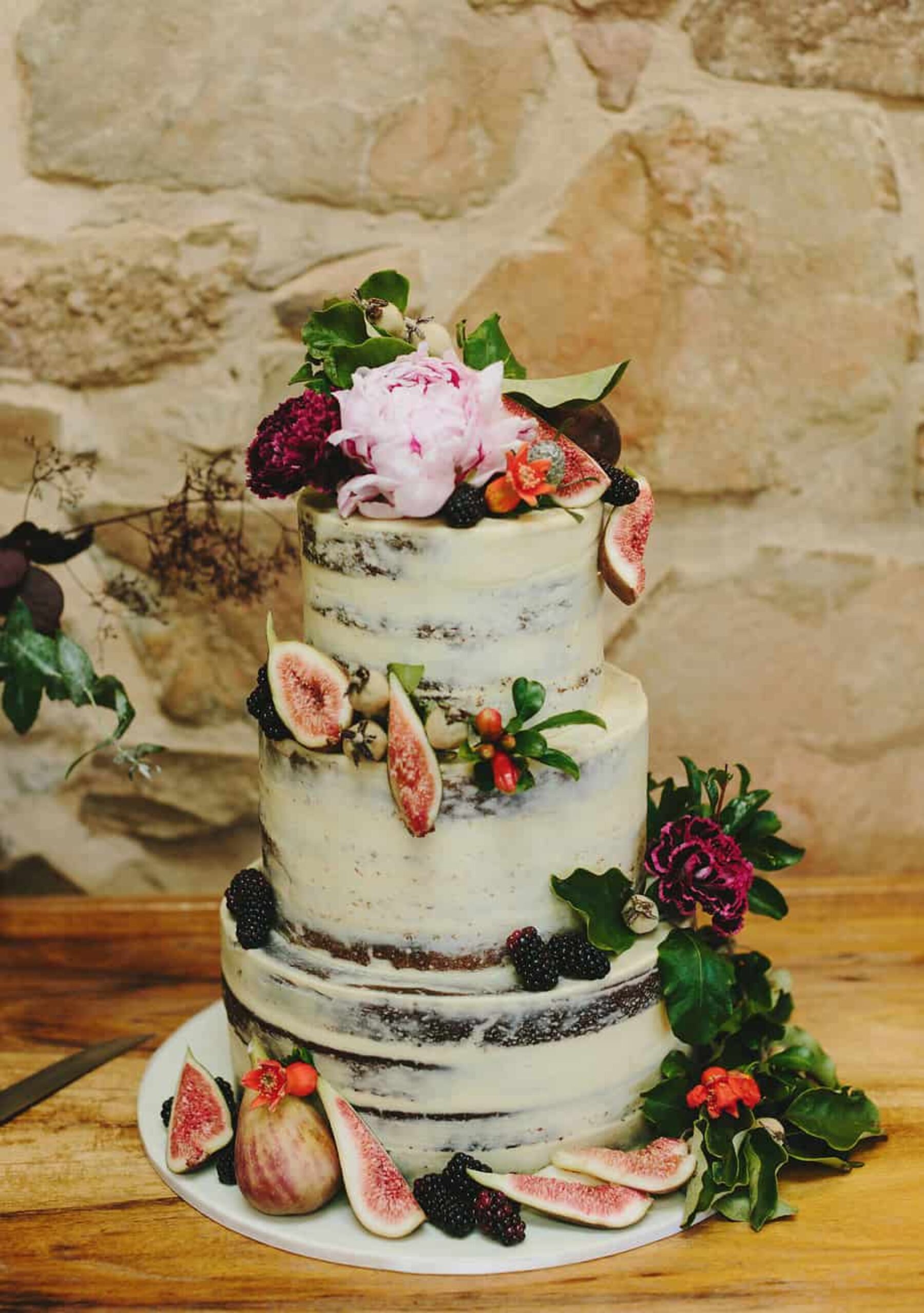 layered mud wedding cake with fresh figs and flowers