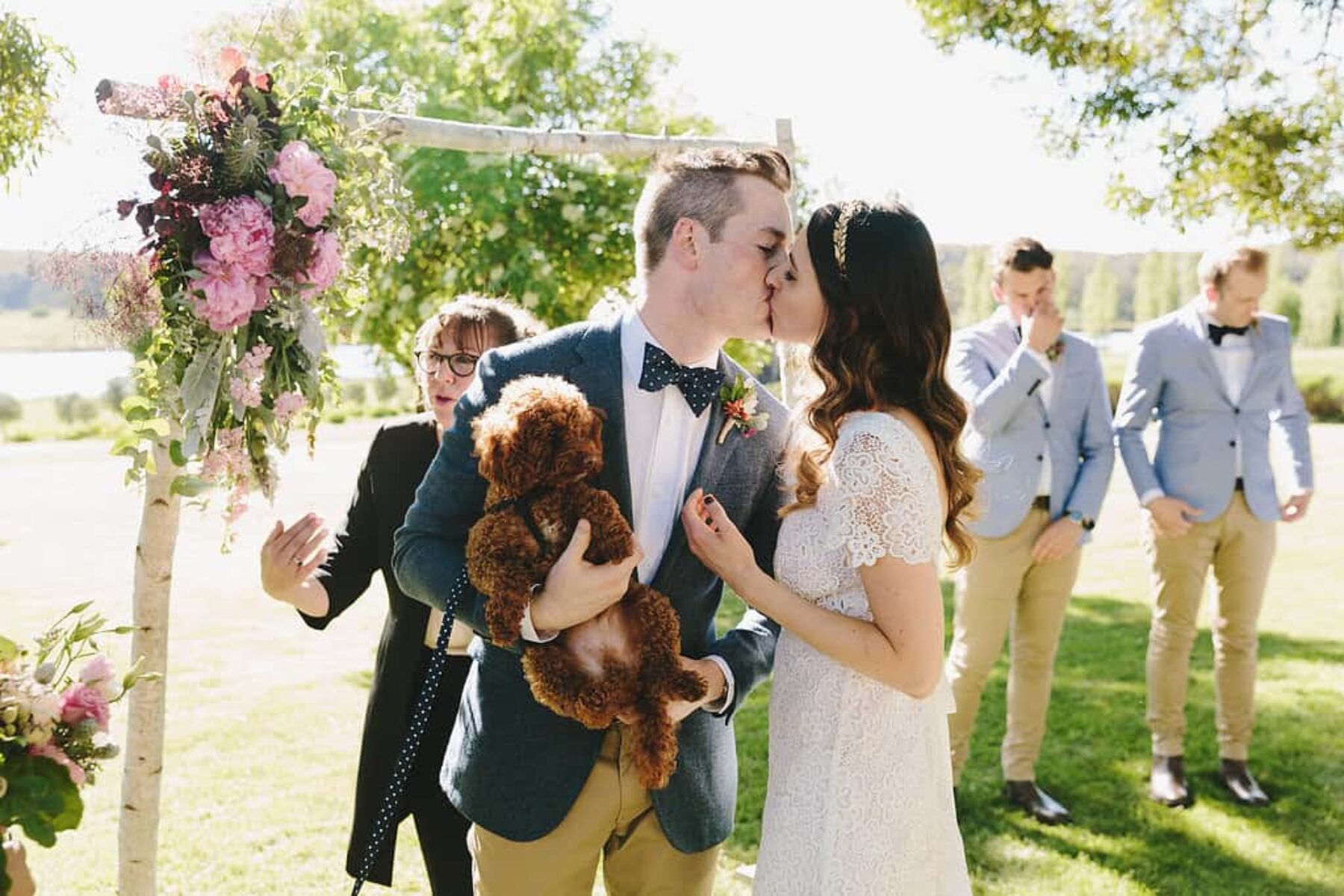 bride and groom with poodle puppy