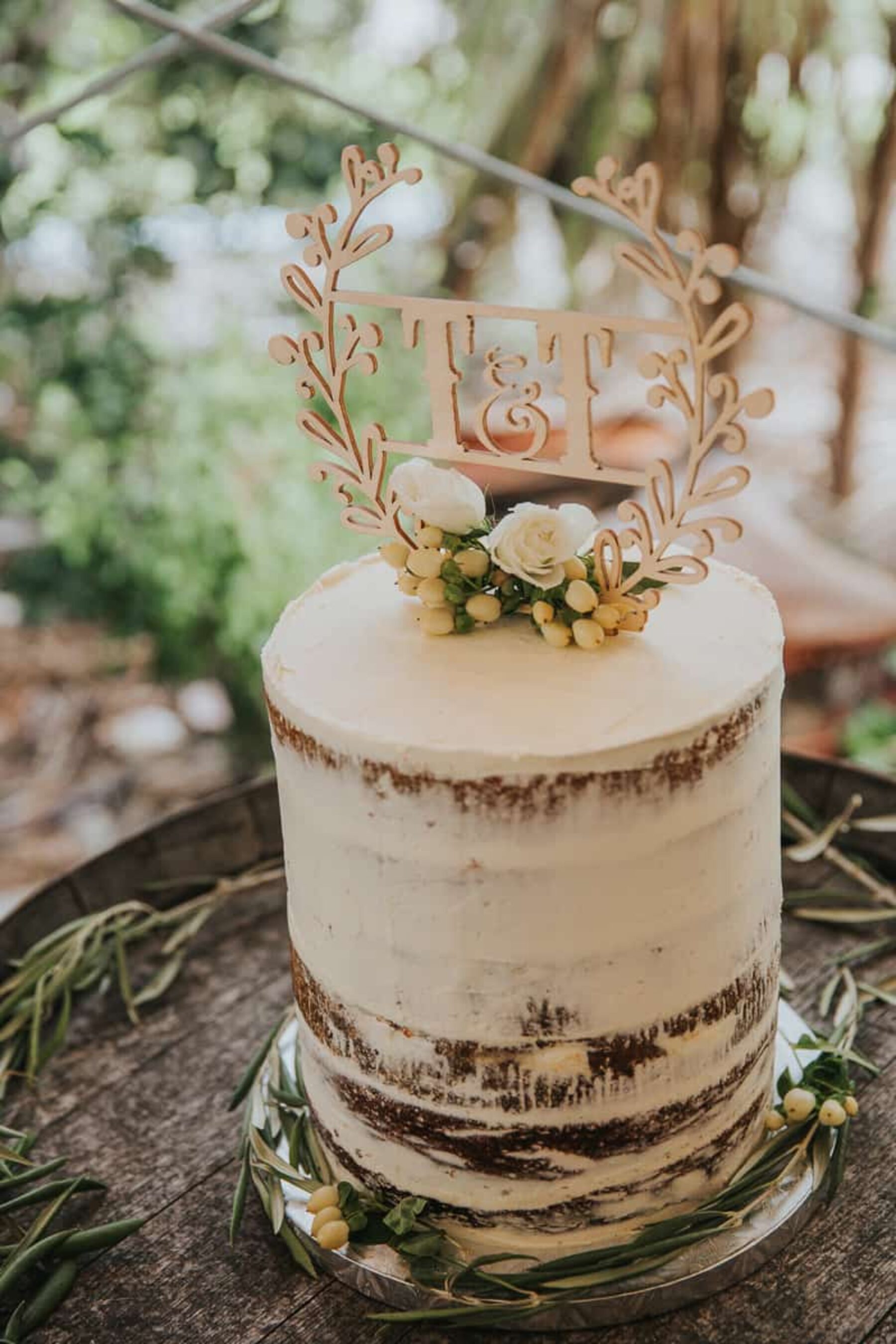 semi-naked wedding cake with wooden monogram topper