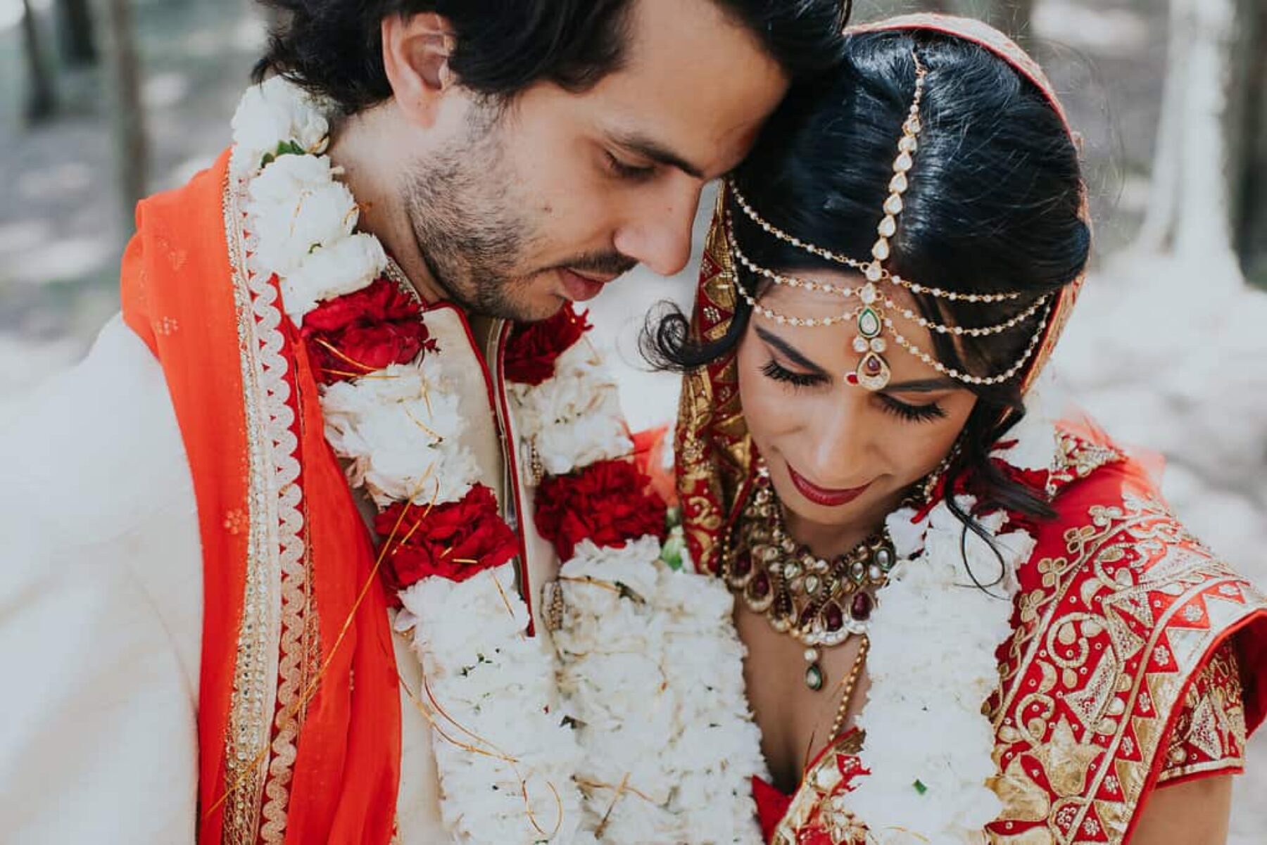 Hindu bride and groom in vibrant red and gold wedding attire