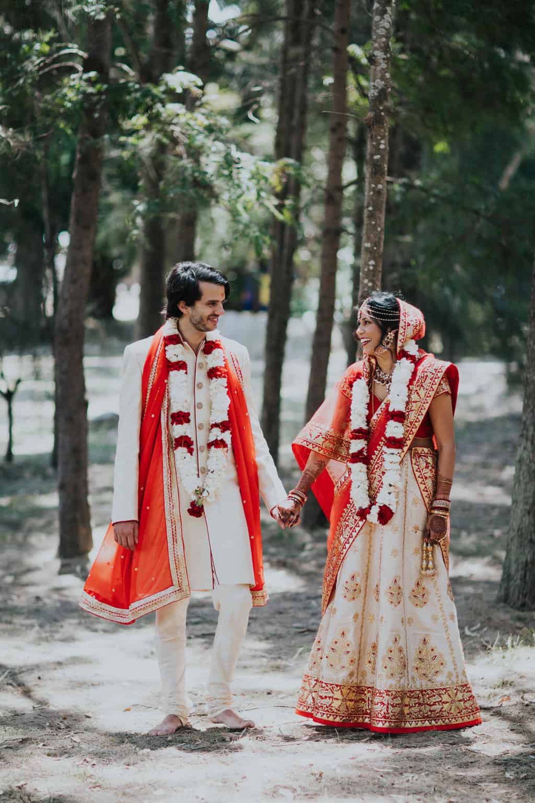 Hindu bride and groom in vibrant red and gold wedding attire