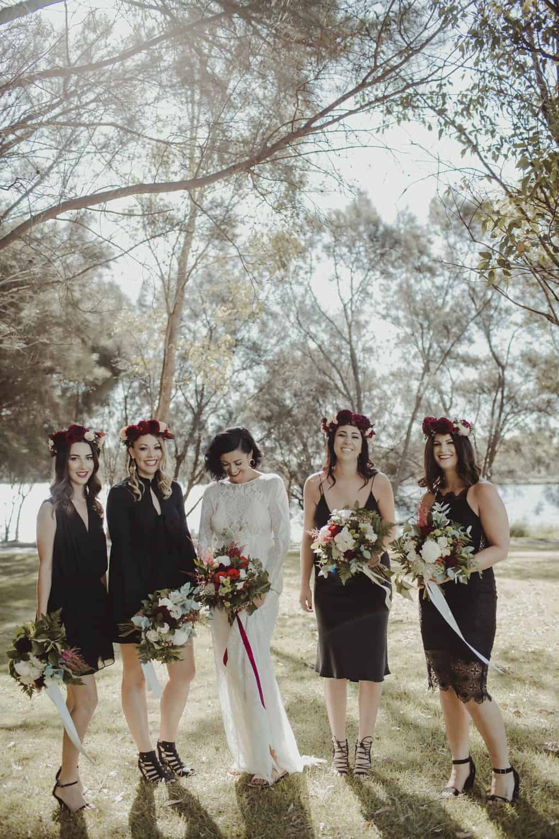 bridesmaids in black dresses and flower crowns