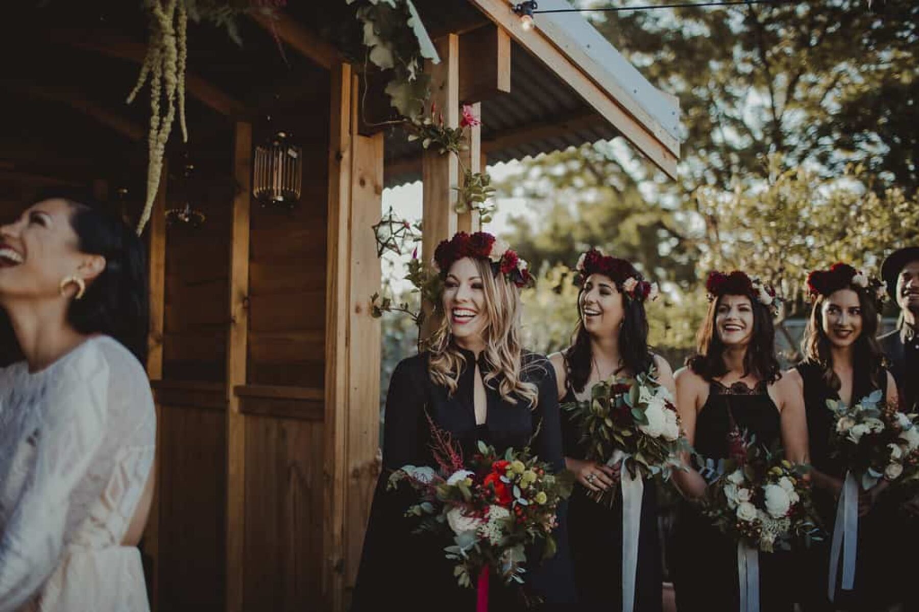 bridesmaids in black dresses and flower crowns