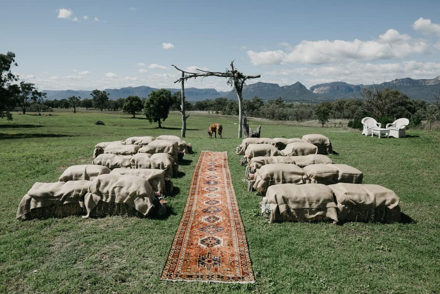 farm wedding backdrop with hay bales and Persian rug runner