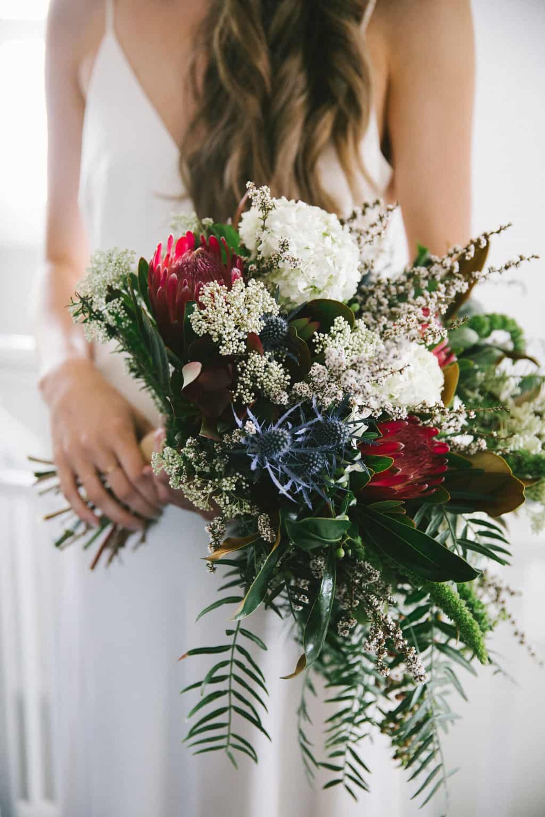 unstructured bridal bouquet with protea and thistle