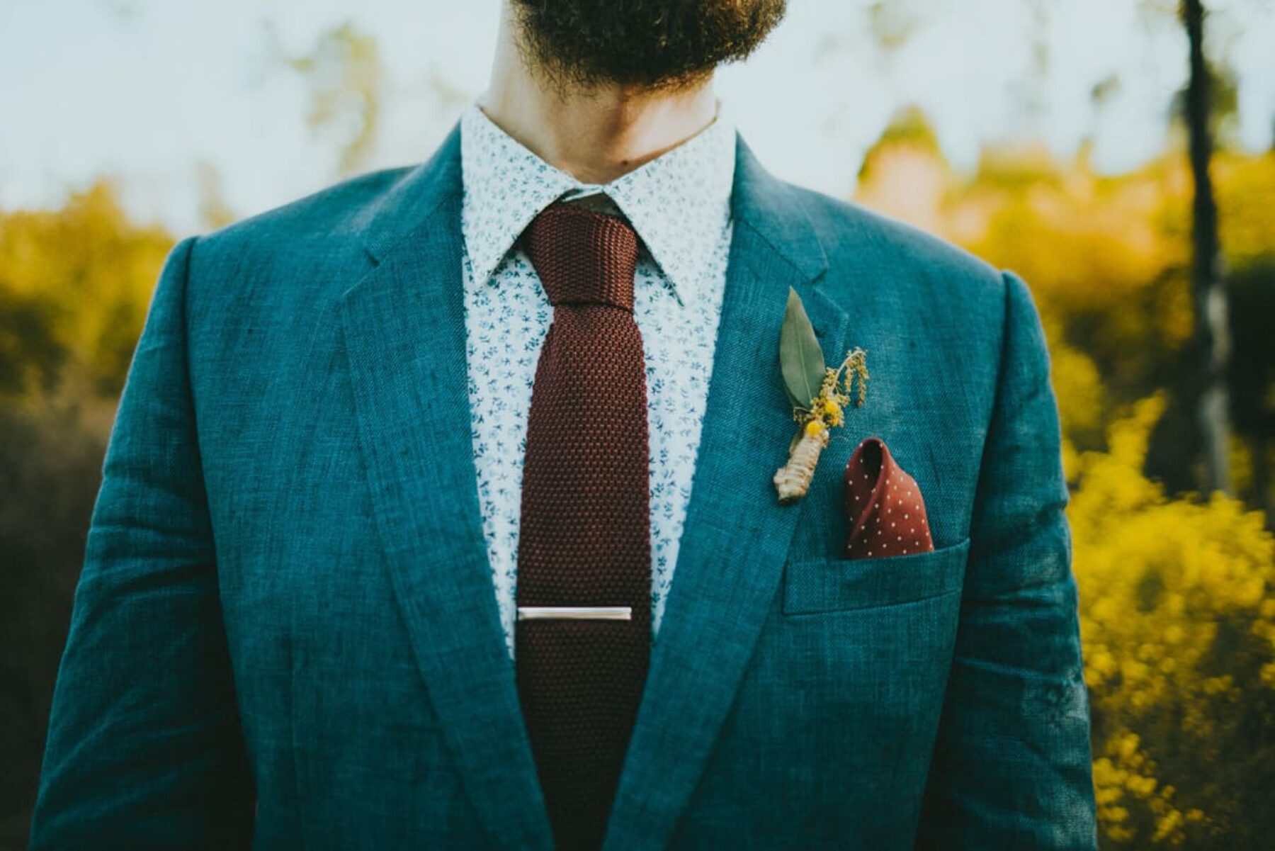 hipster groom with floral shirt and knitted tie