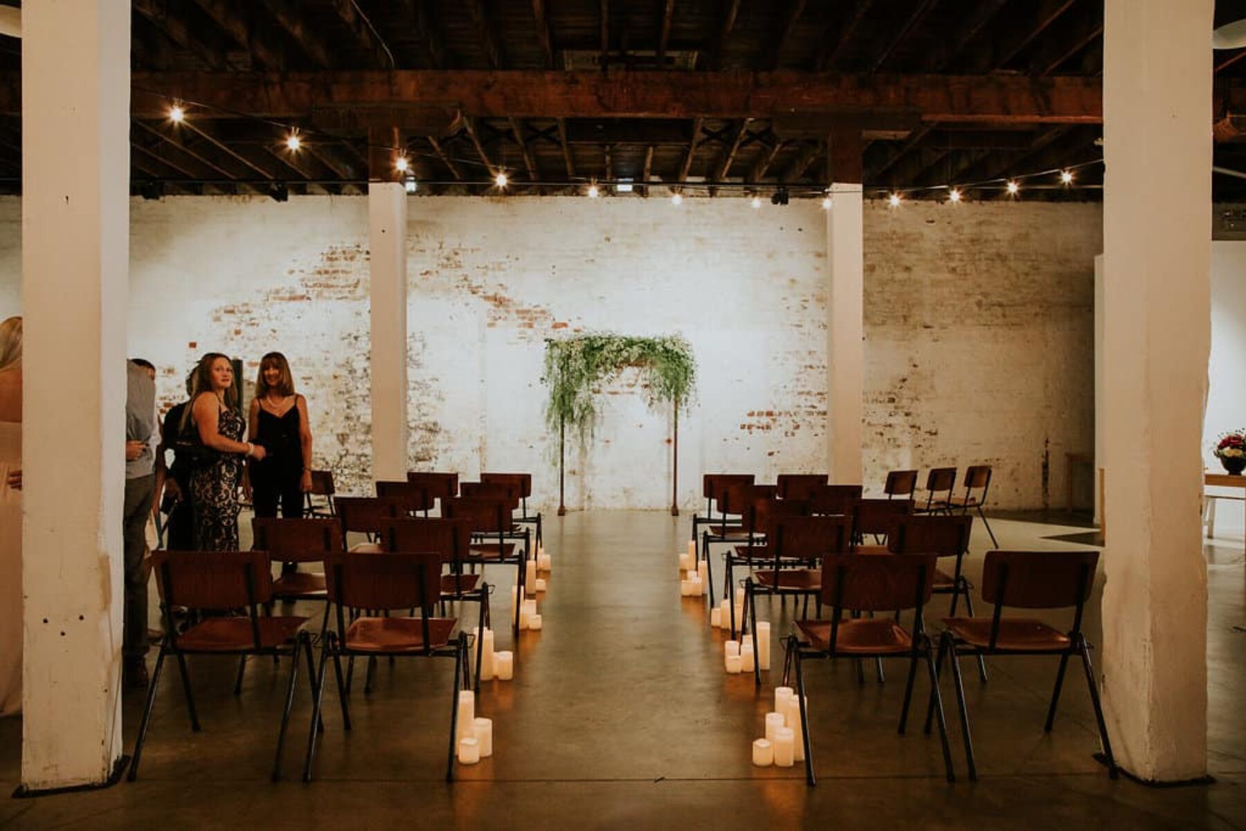industrial wedding with greenery arbour