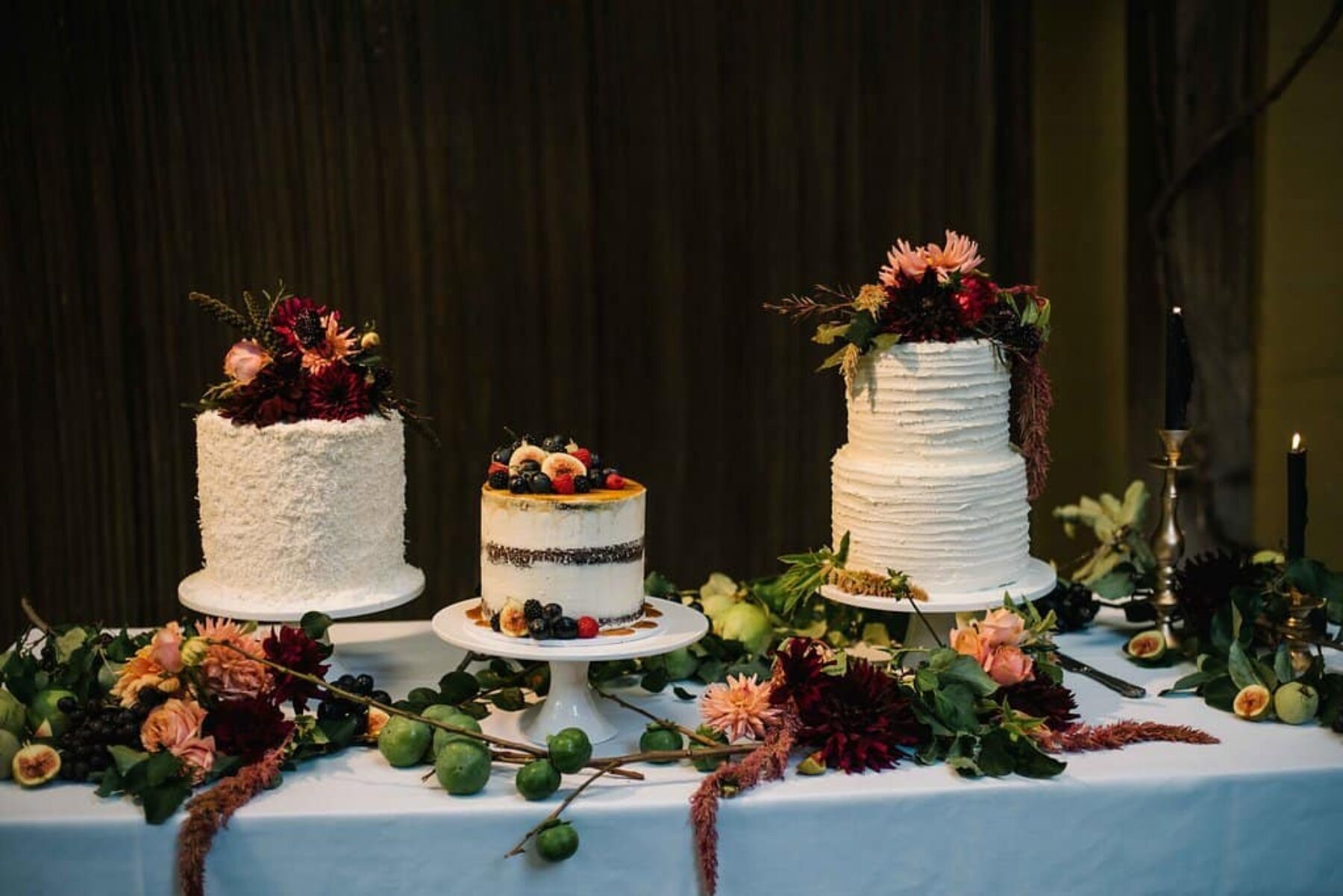 trio of wedding cakes with fresh fruit and flower toppers