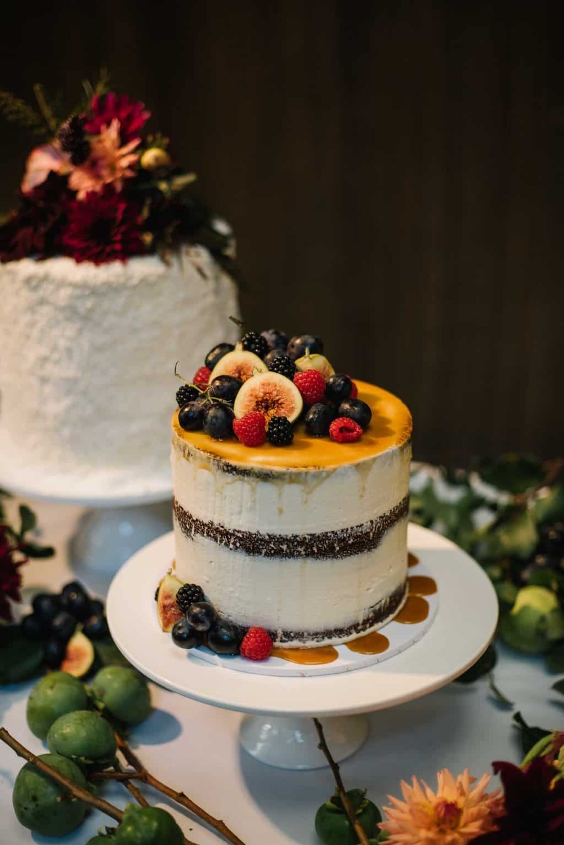 trio of wedding cakes with fresh fruit and flower toppers