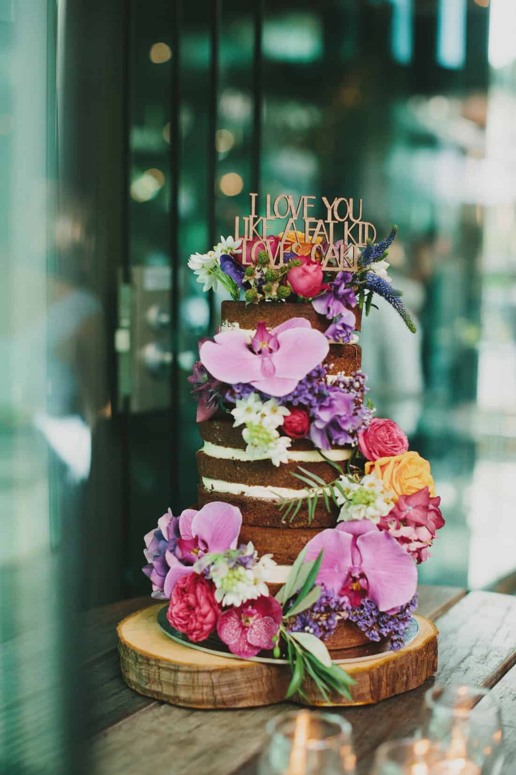 amazing naked wedding cake with loads of fresh flowers