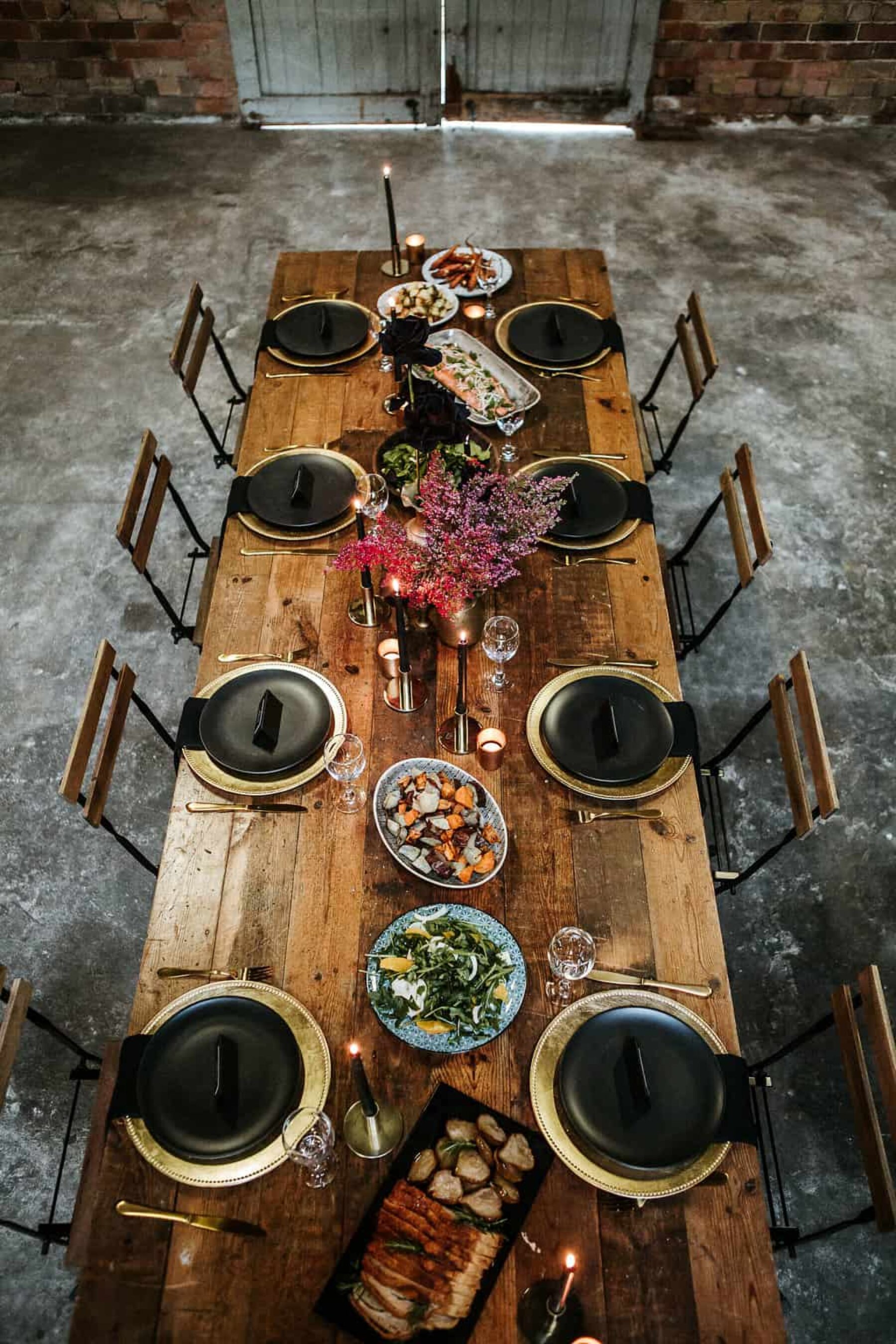 industrial wedding tablescape with black plates and gold cutlery