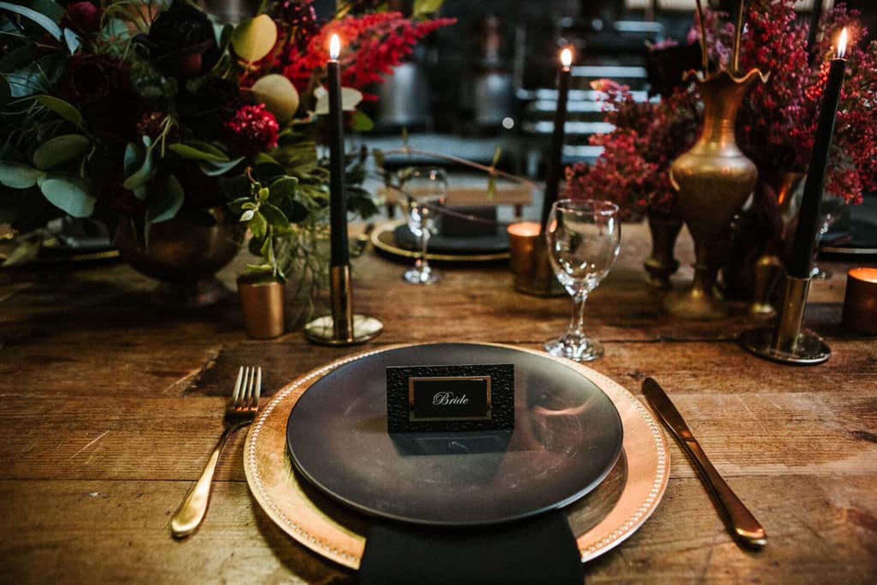 industrial wedding tablescape with black plates and gold cutlery