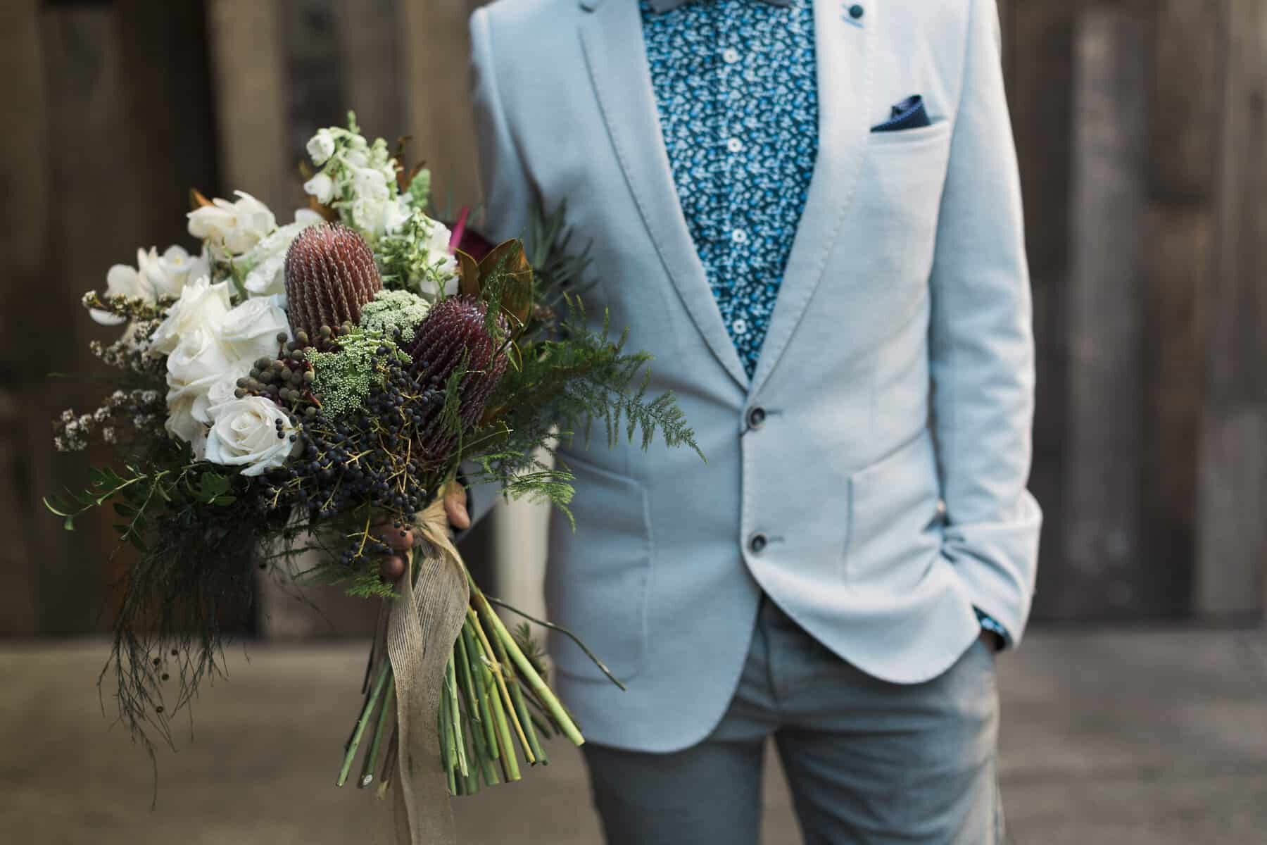 Stylish groom in pale blue blazer and floral print shirt