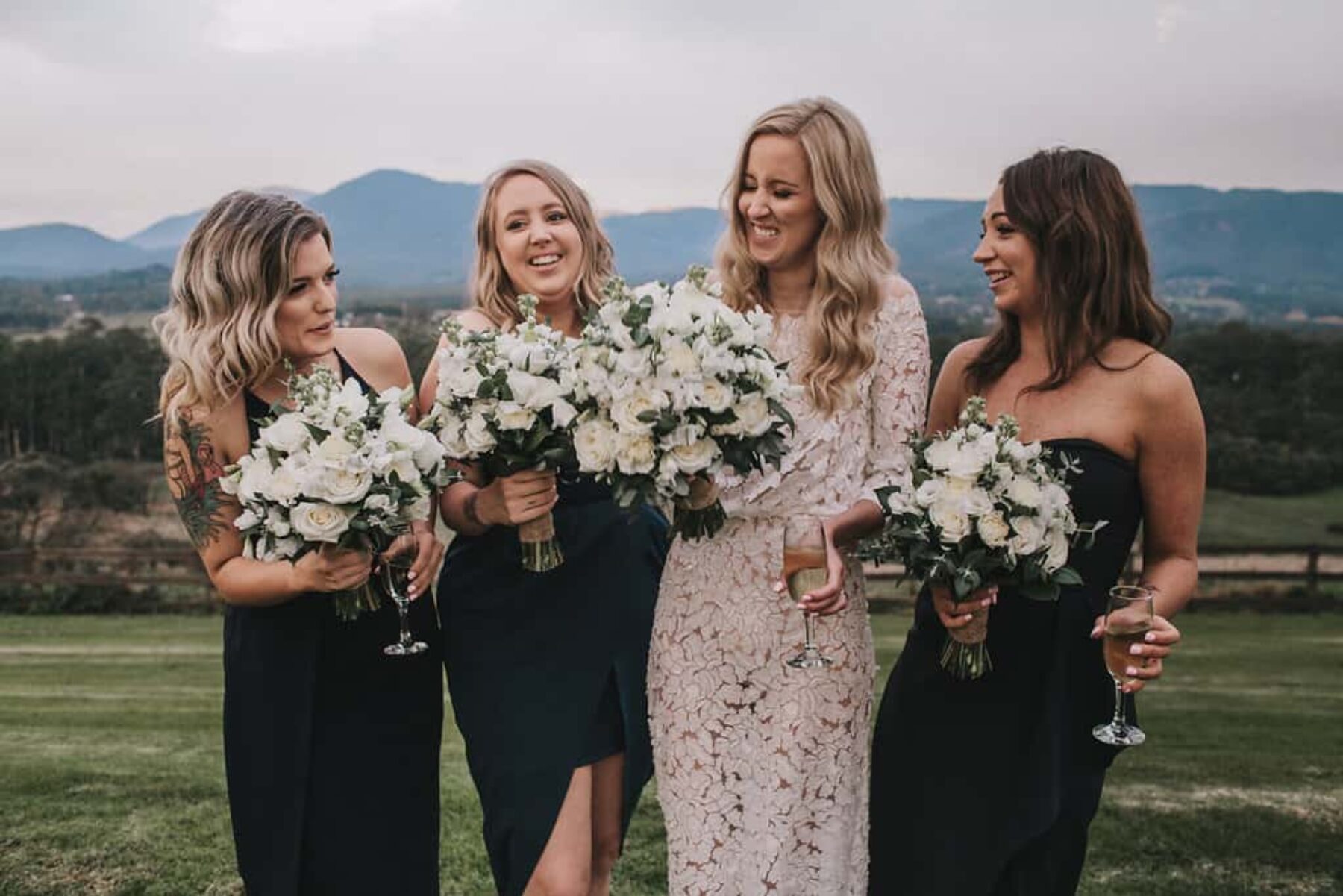 bridemaids in mixed navy dresses with green and white bouquets