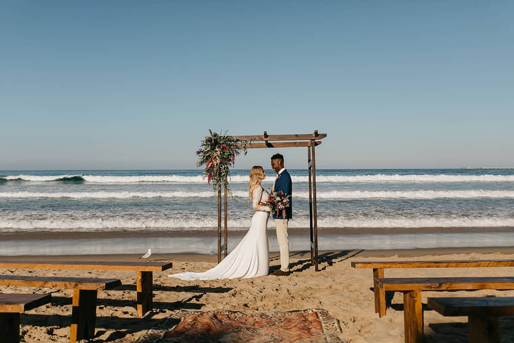 Beach wedding with floral timber arbour