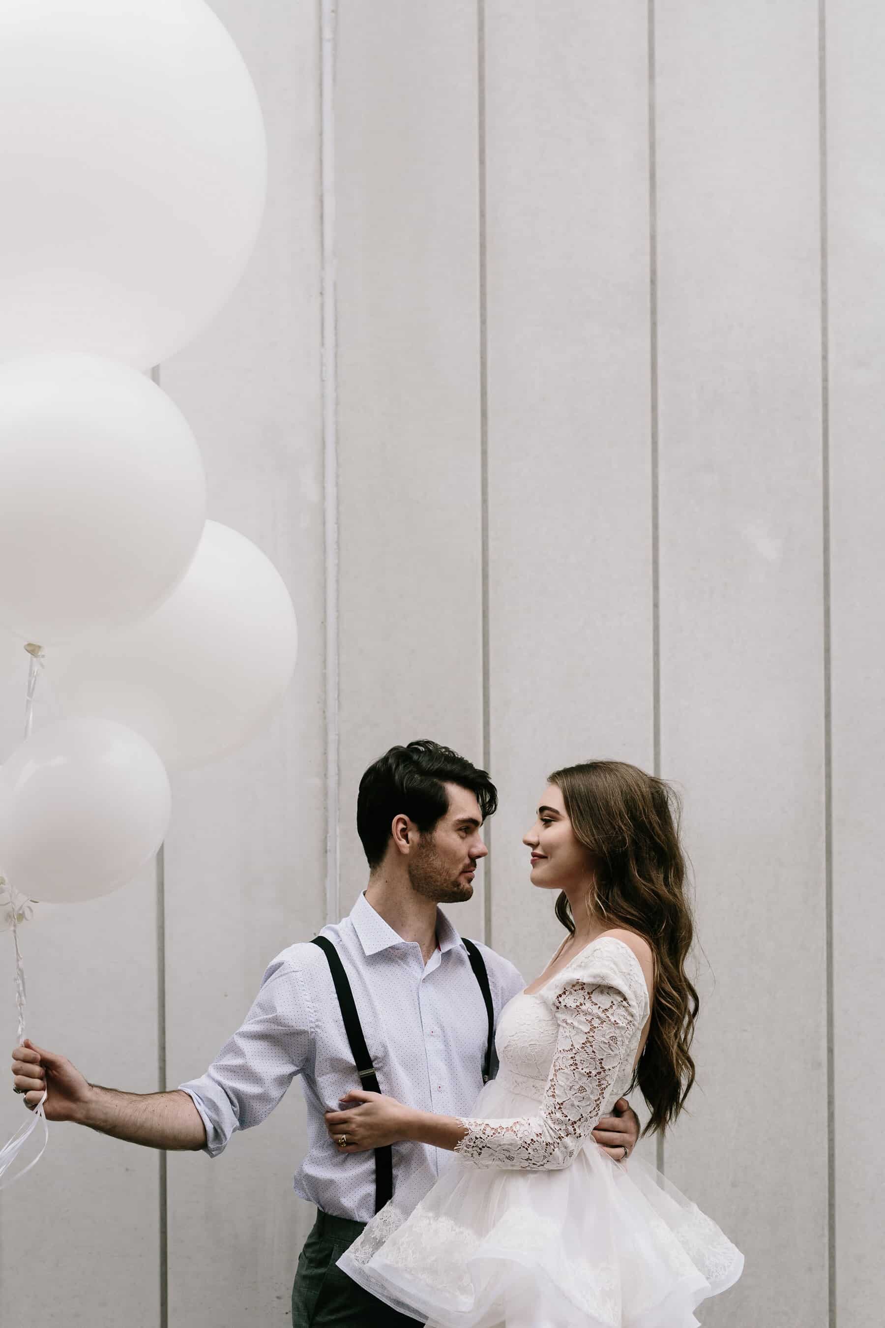 bride and groom with giant white balloons