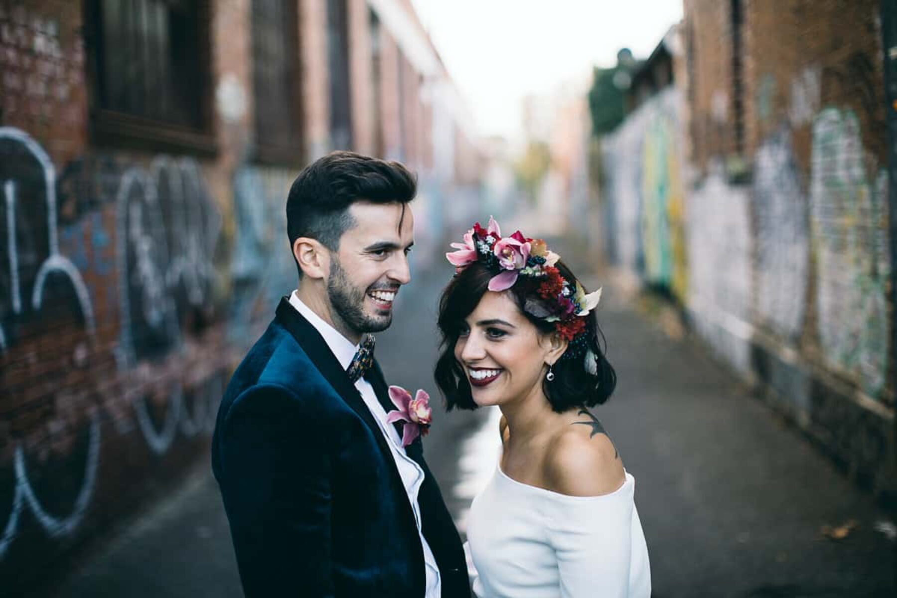modern bride in off-shoulder wedding dress and berry-toned flower crown