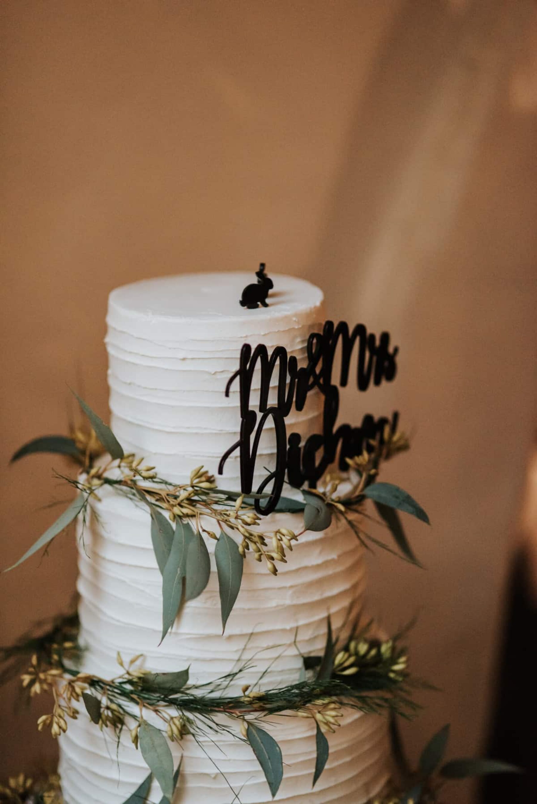 simple 3 tier wedding cake decorated with gum leaves
