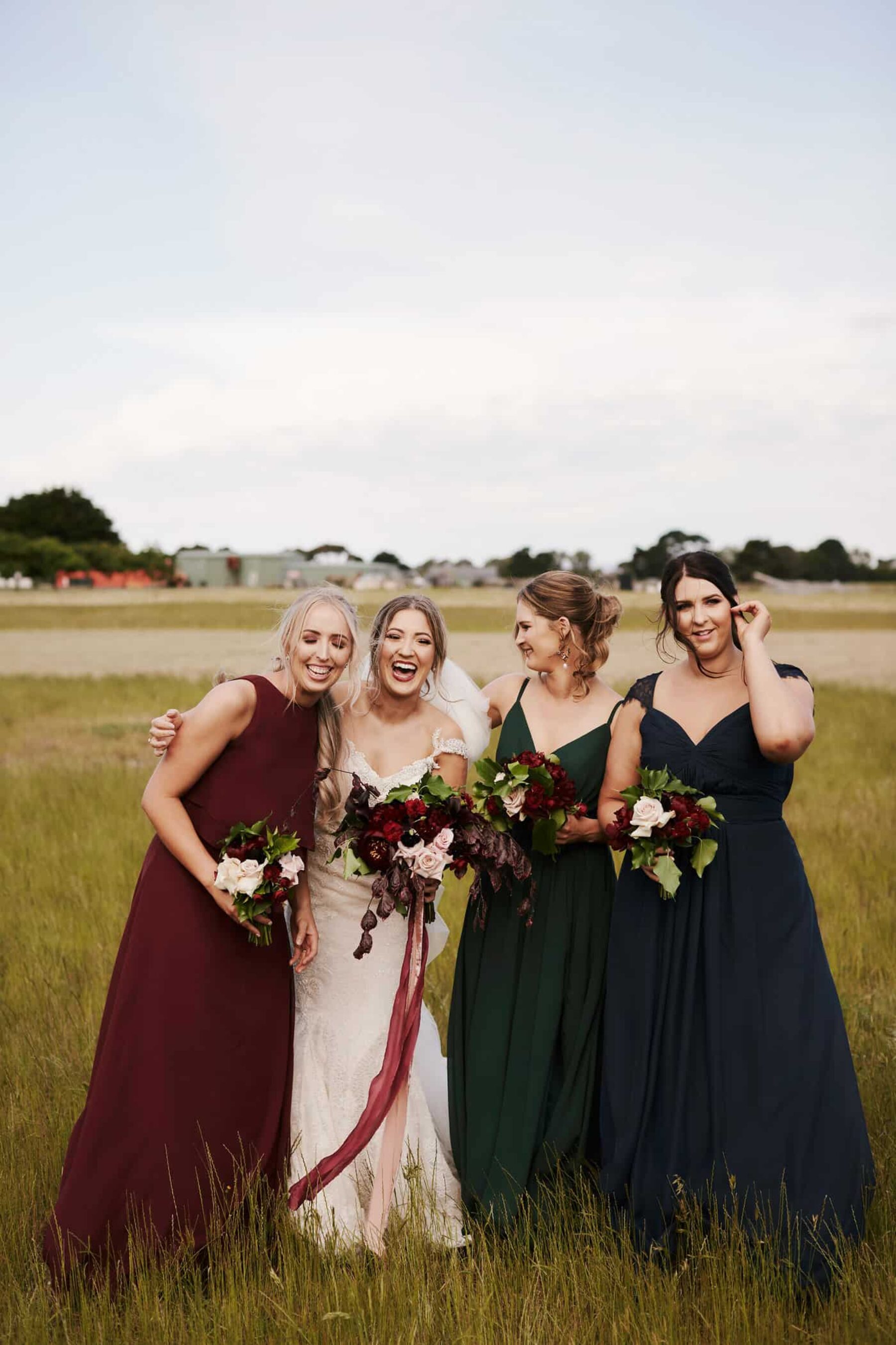 bridesmaids in navy, emerald and burgundy dresses