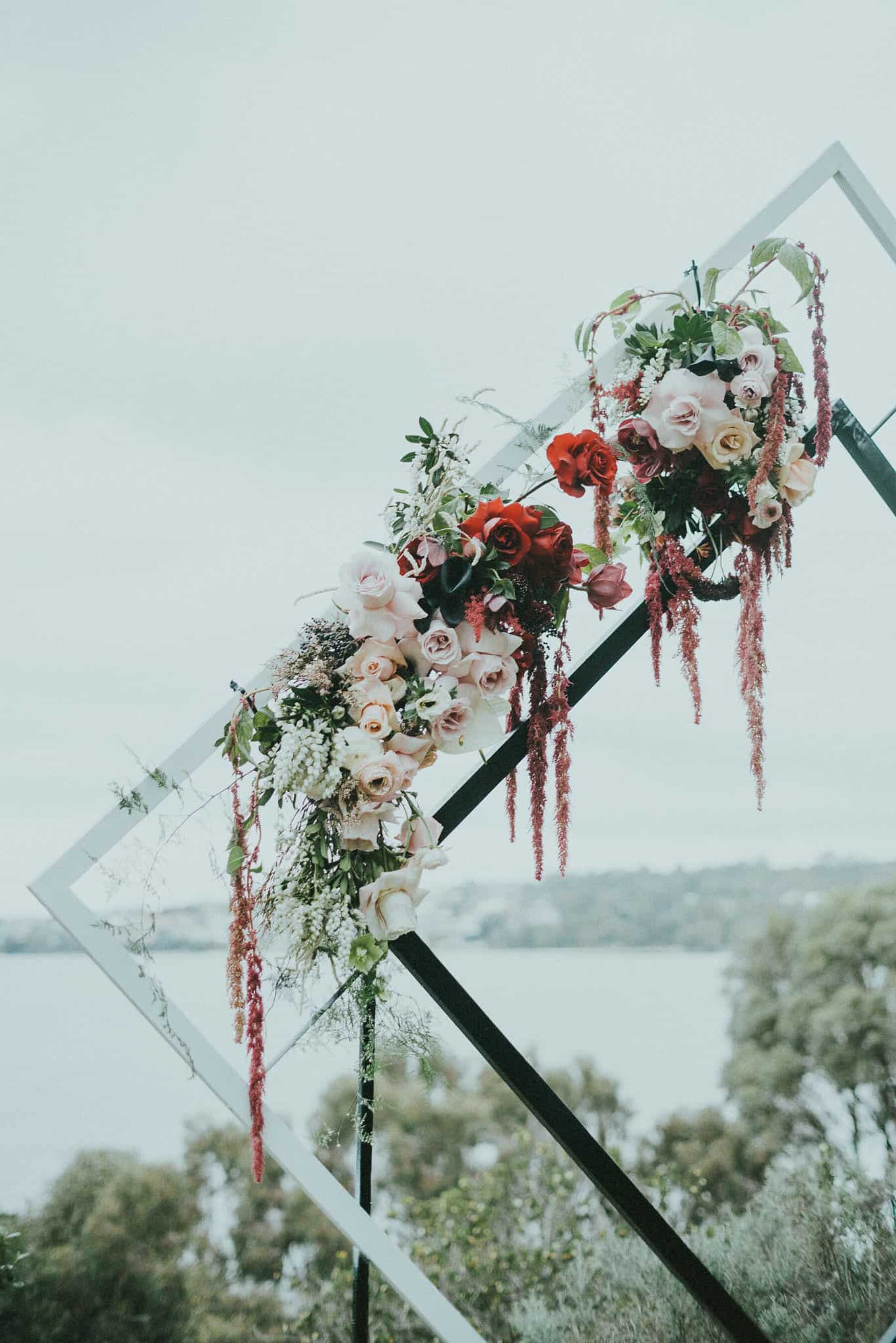 modern diamond wedding arbour with blush and burgundy flowers