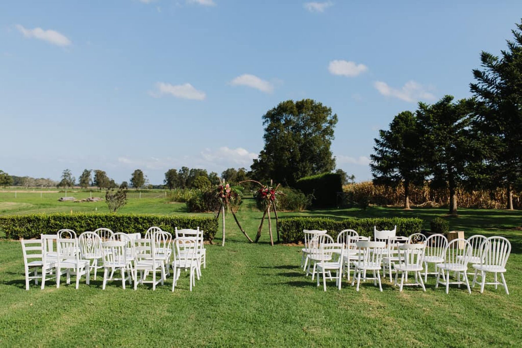 garden wedding with mixed vintage white chairs