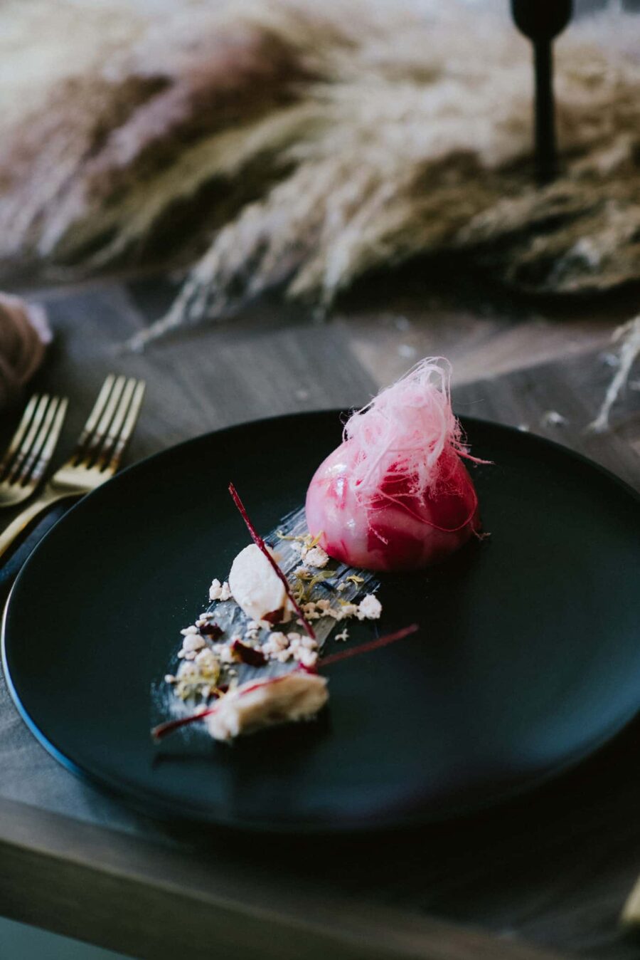 contemporary pink dessert on black plate