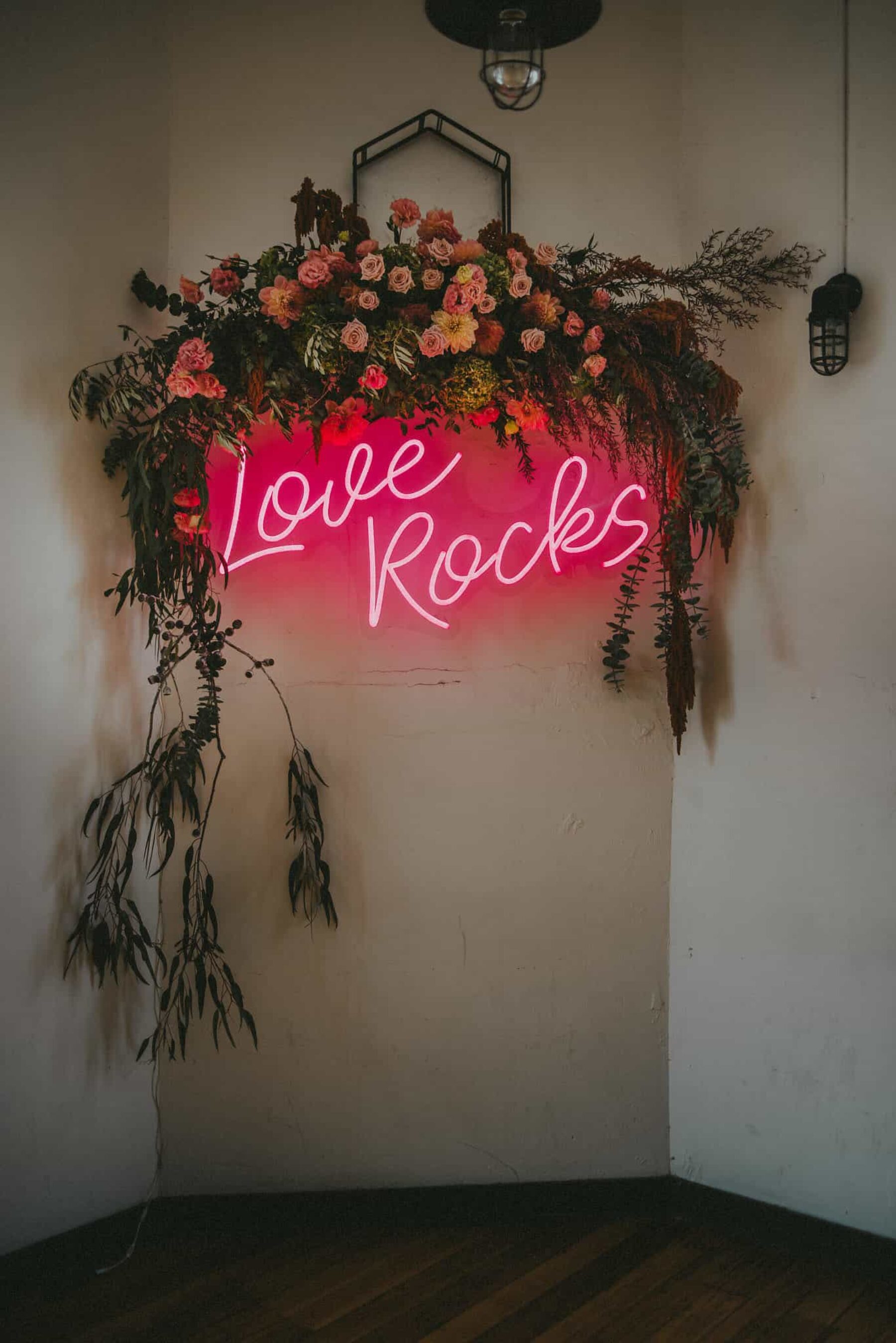 floral wedding backdrop with pink neon sign
