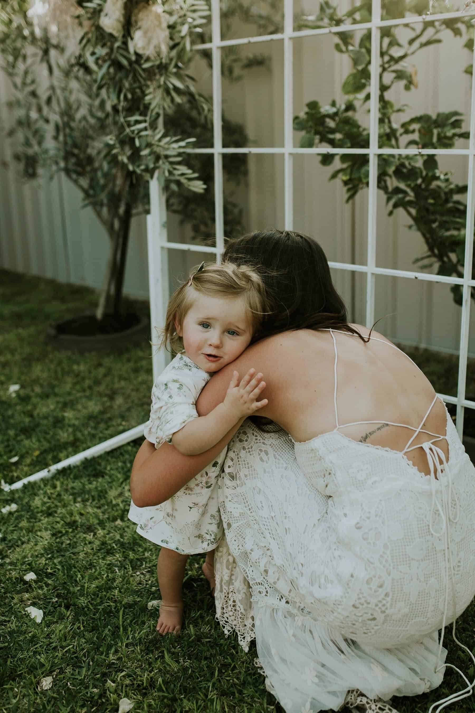 boho backyard hugging her little daughter