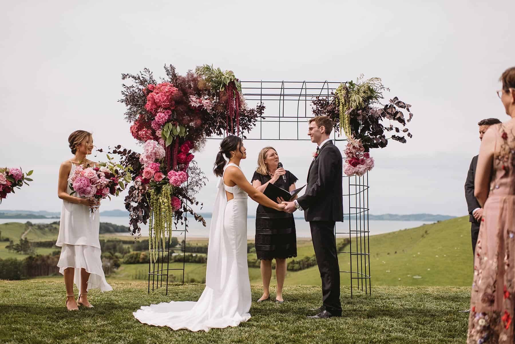 wire wedding arbour with pink and burgundy flowers