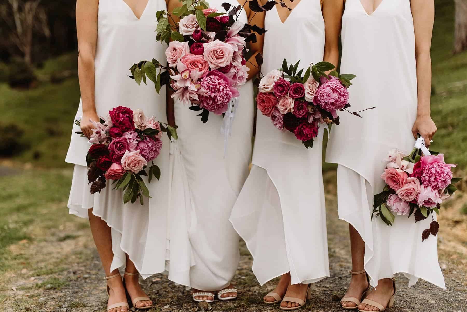 modern bridesmaids all in white with mixed pink bouquets