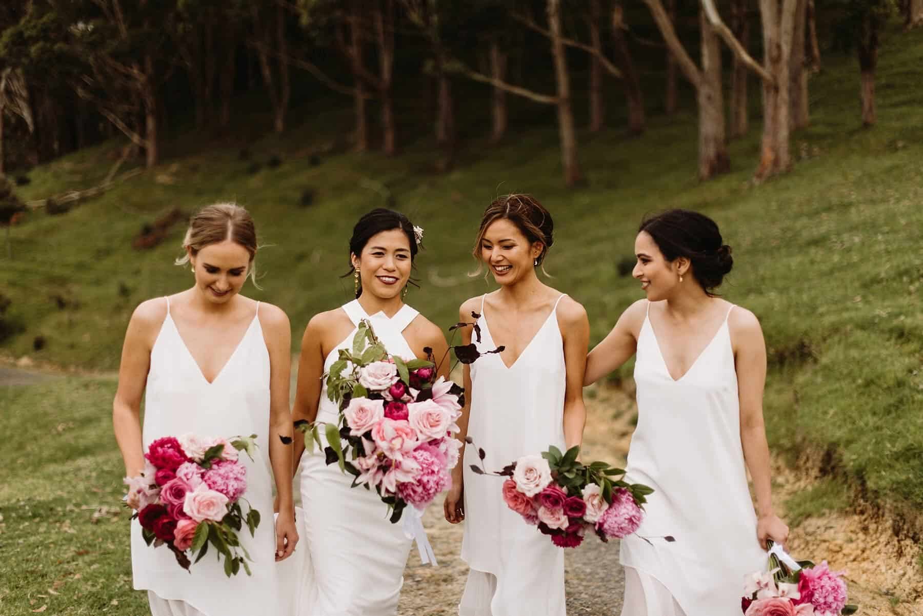 modern bridesmaids all in white with mixed pink bouquets