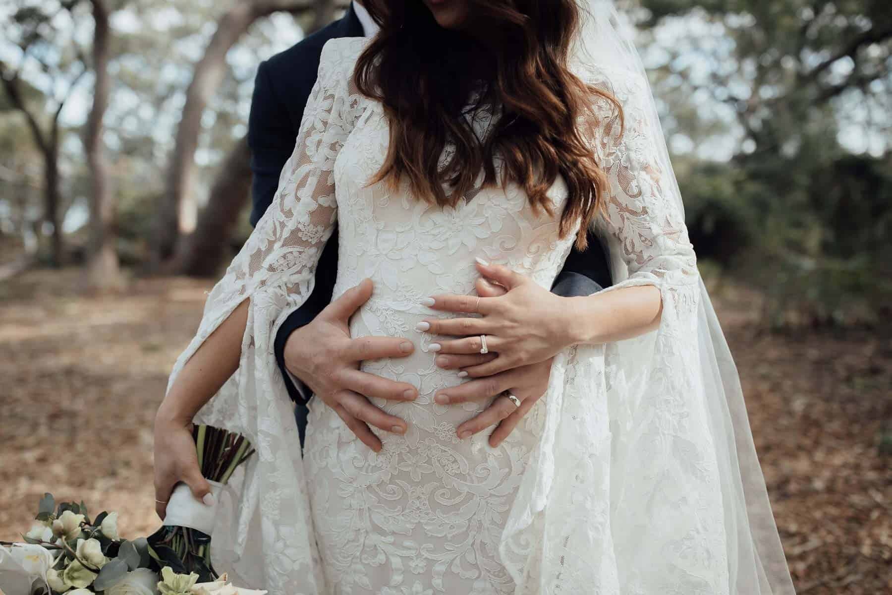 pregnant bride in bell sleeve lace wedding dress by Alex Perry