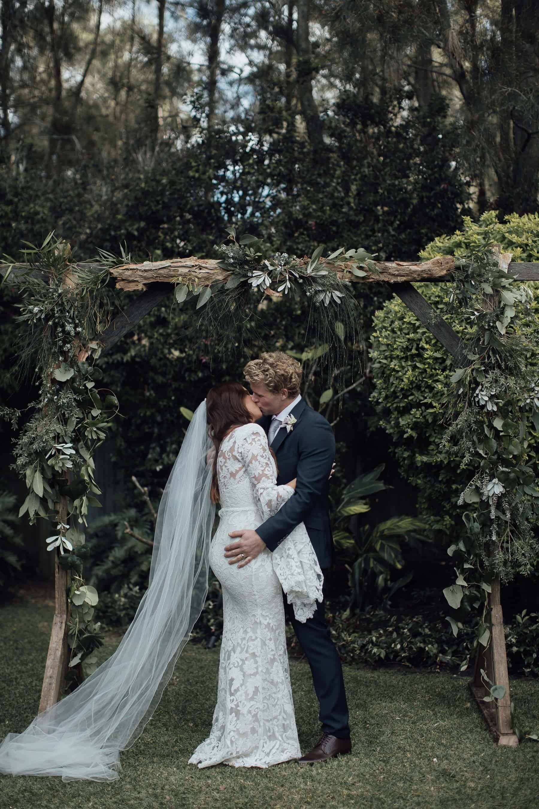 pregnant bride in bell sleeve lace wedding dress by Alex Perry